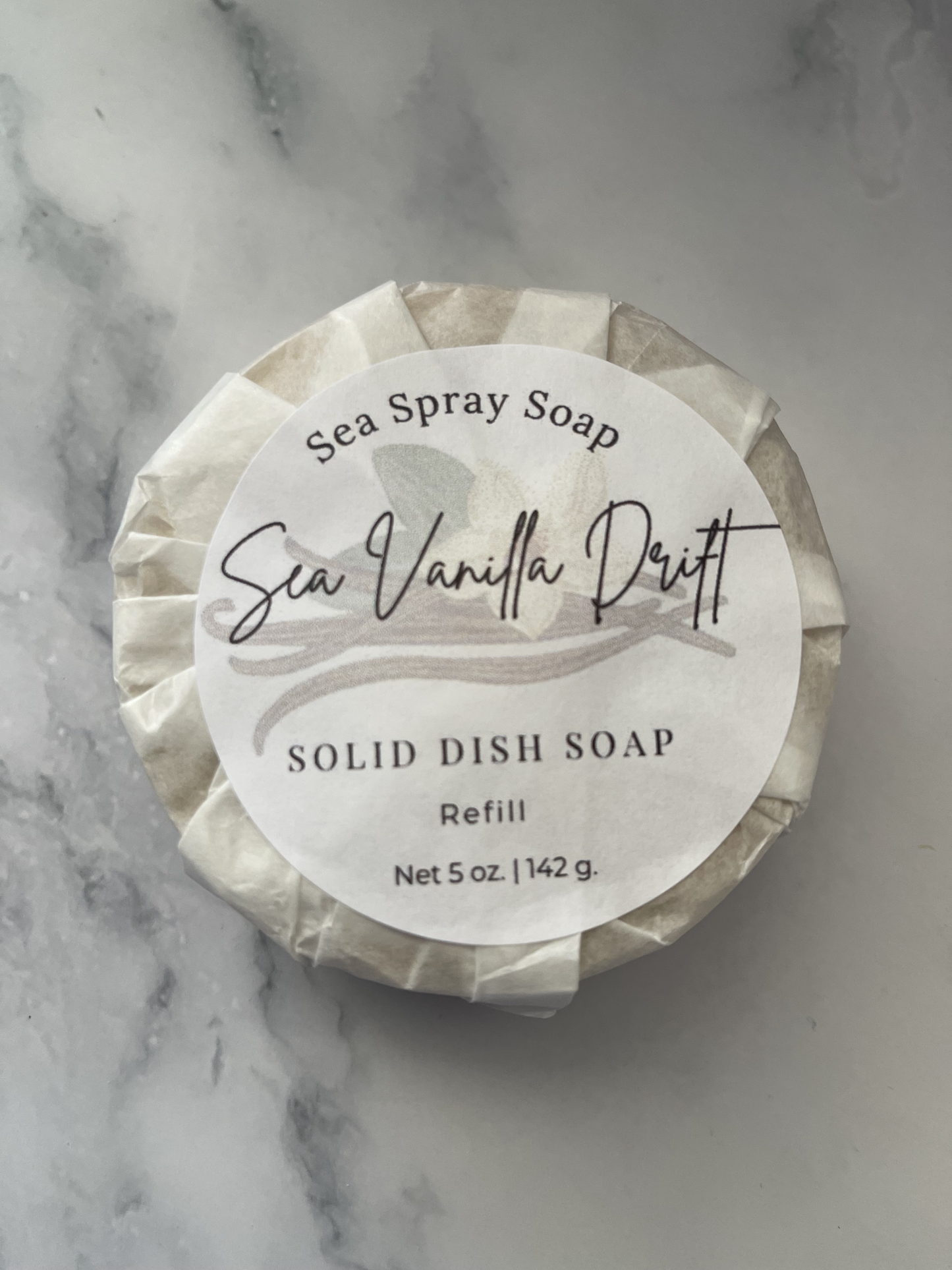 Solid dish soap refill with 'Sea Spray Soap' label on a marble background