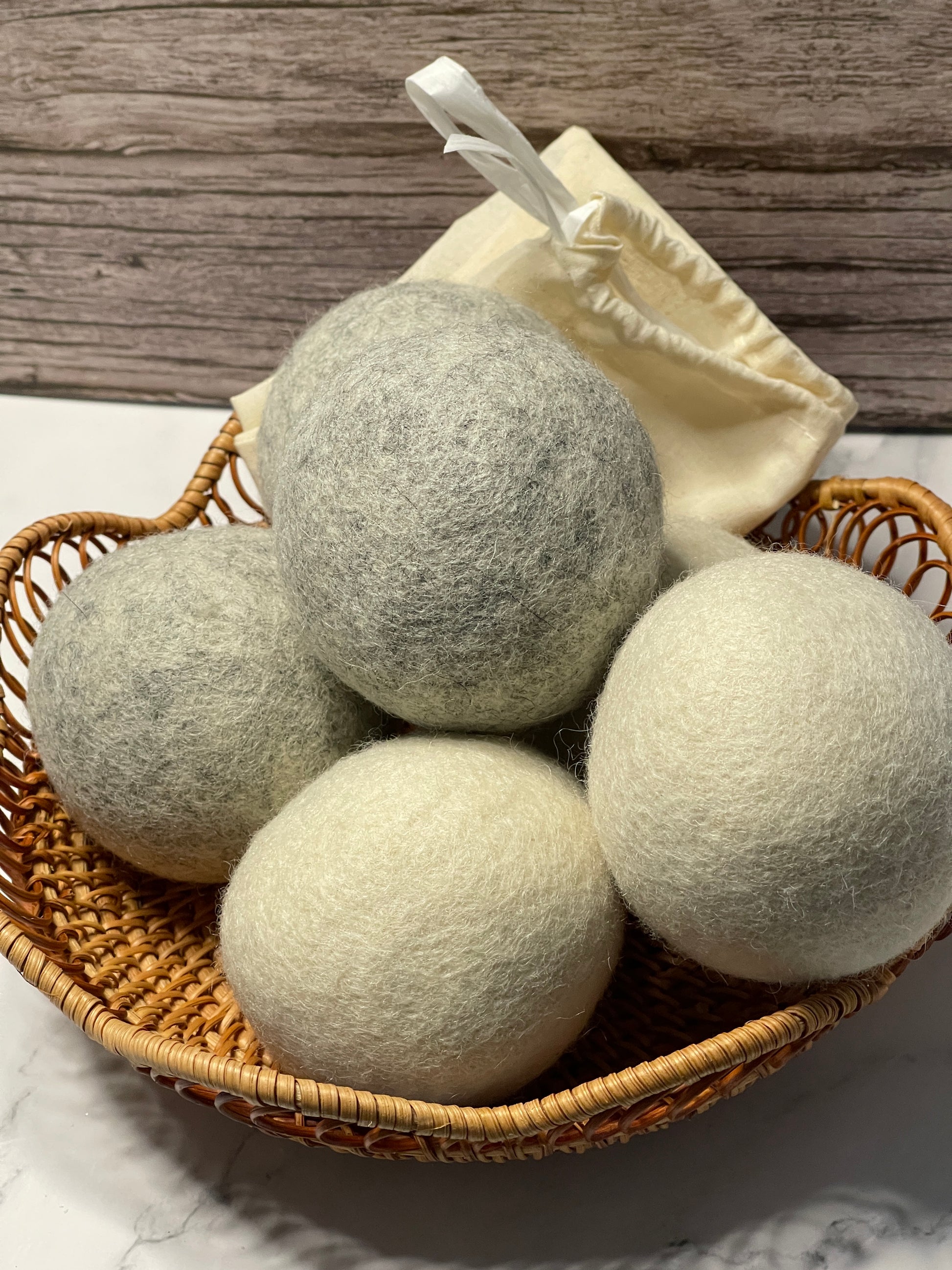 Wool dryer balls in a wicker basket on a wooden surface