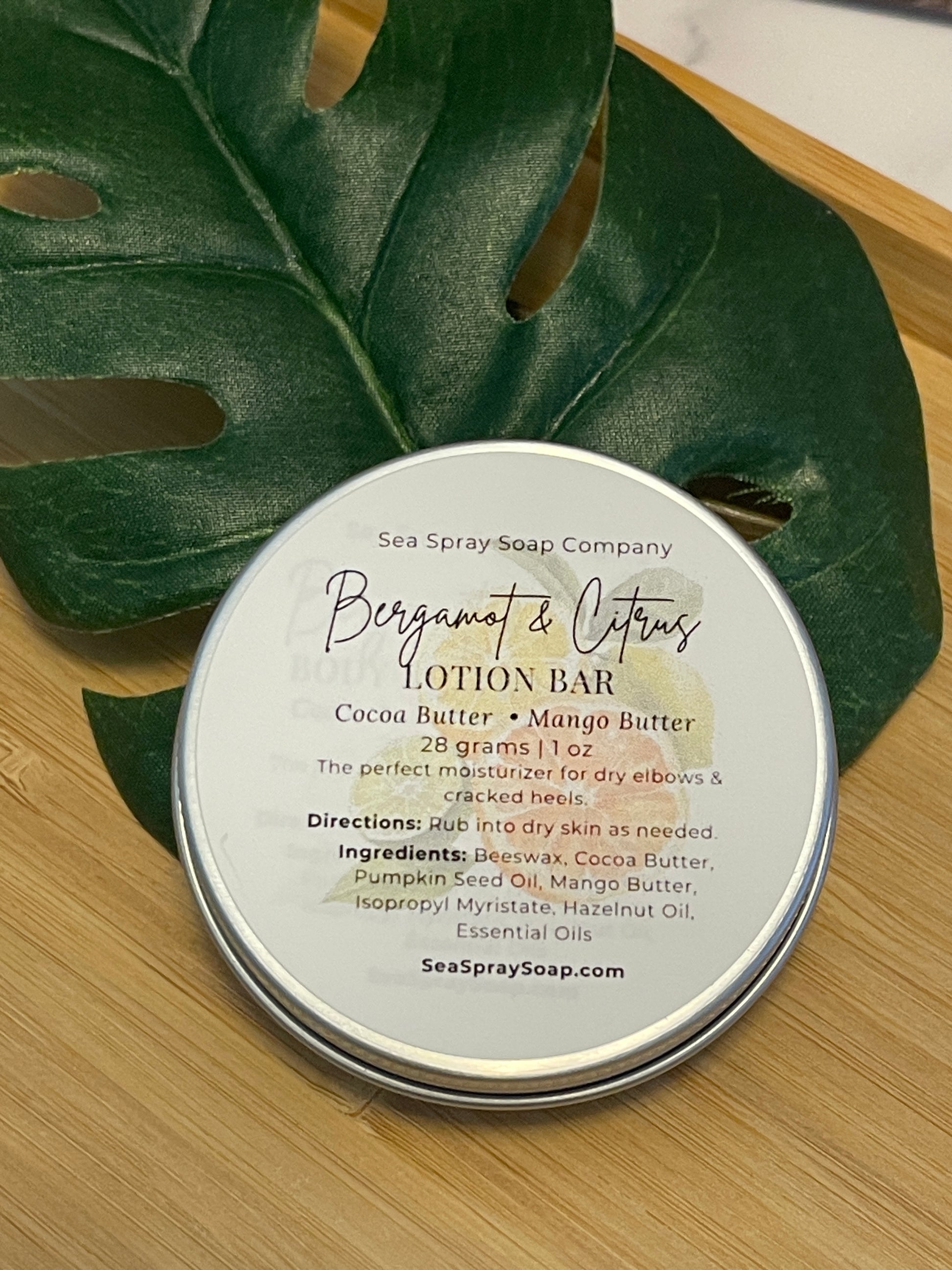 Lotion bar container with label on a leaf on a wooden surface
