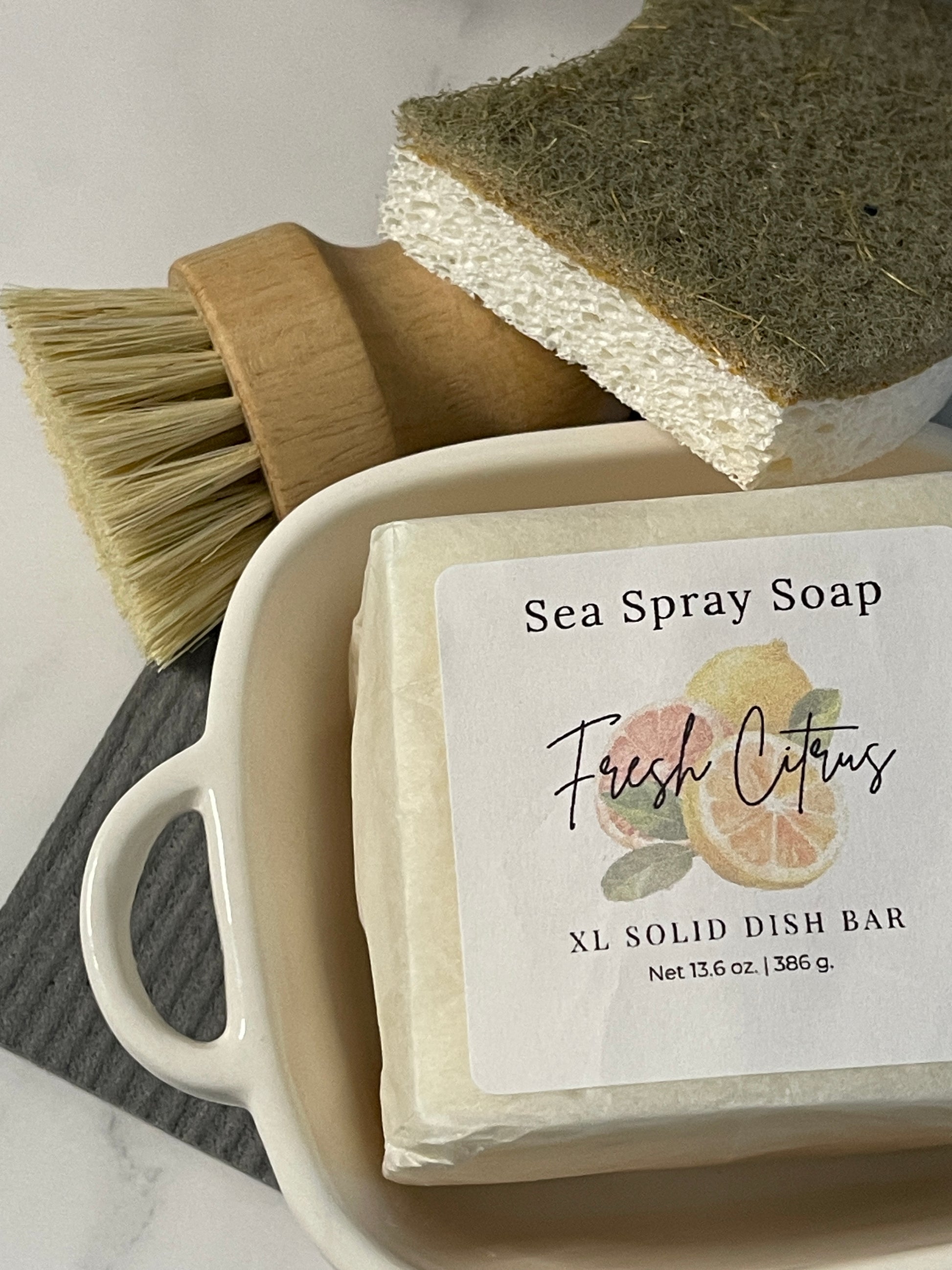 Sea Spray Soap bar with a brush and sponge on a white surface