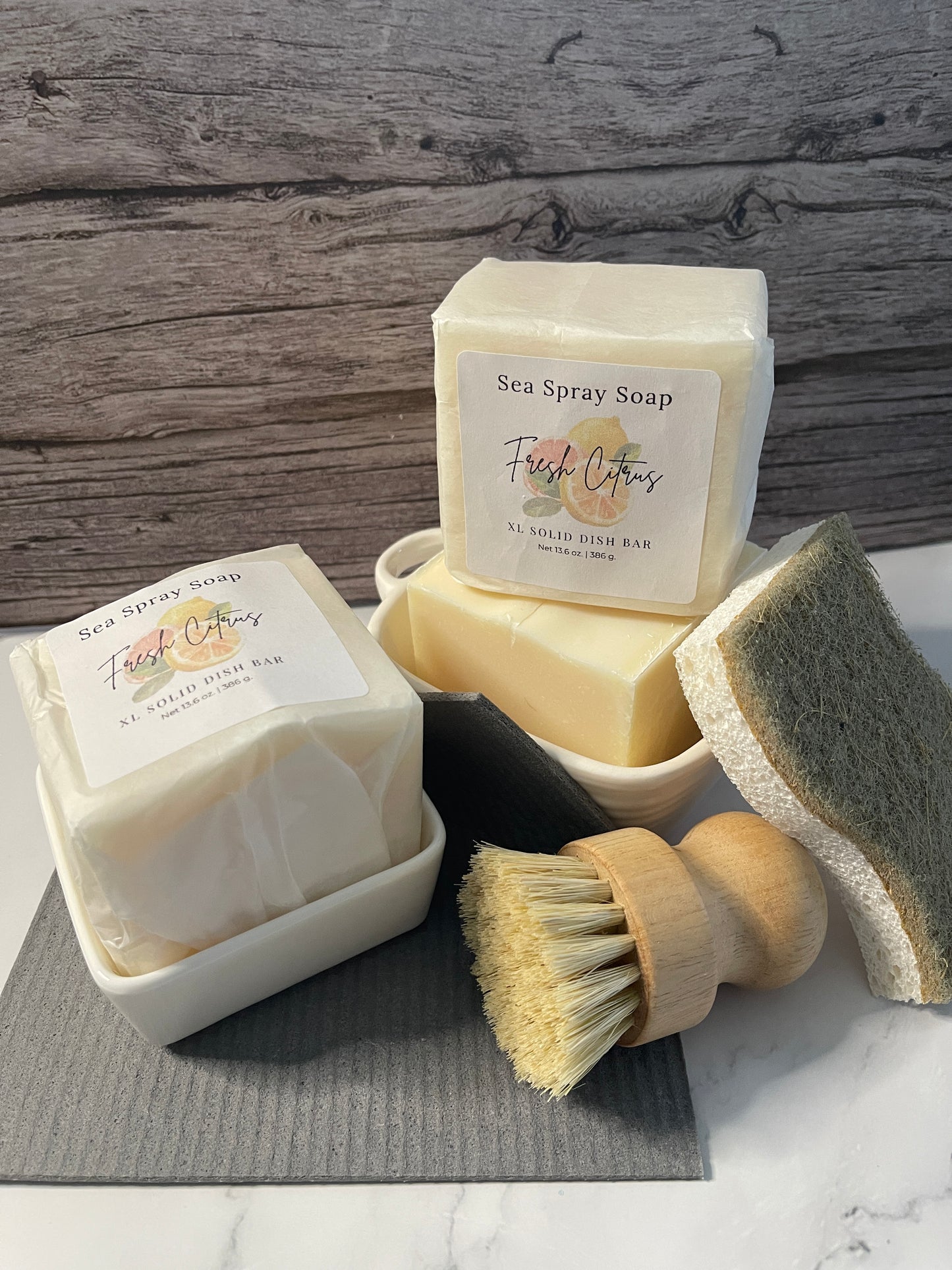 Bar of soap with a brush and sponge on a wooden surface