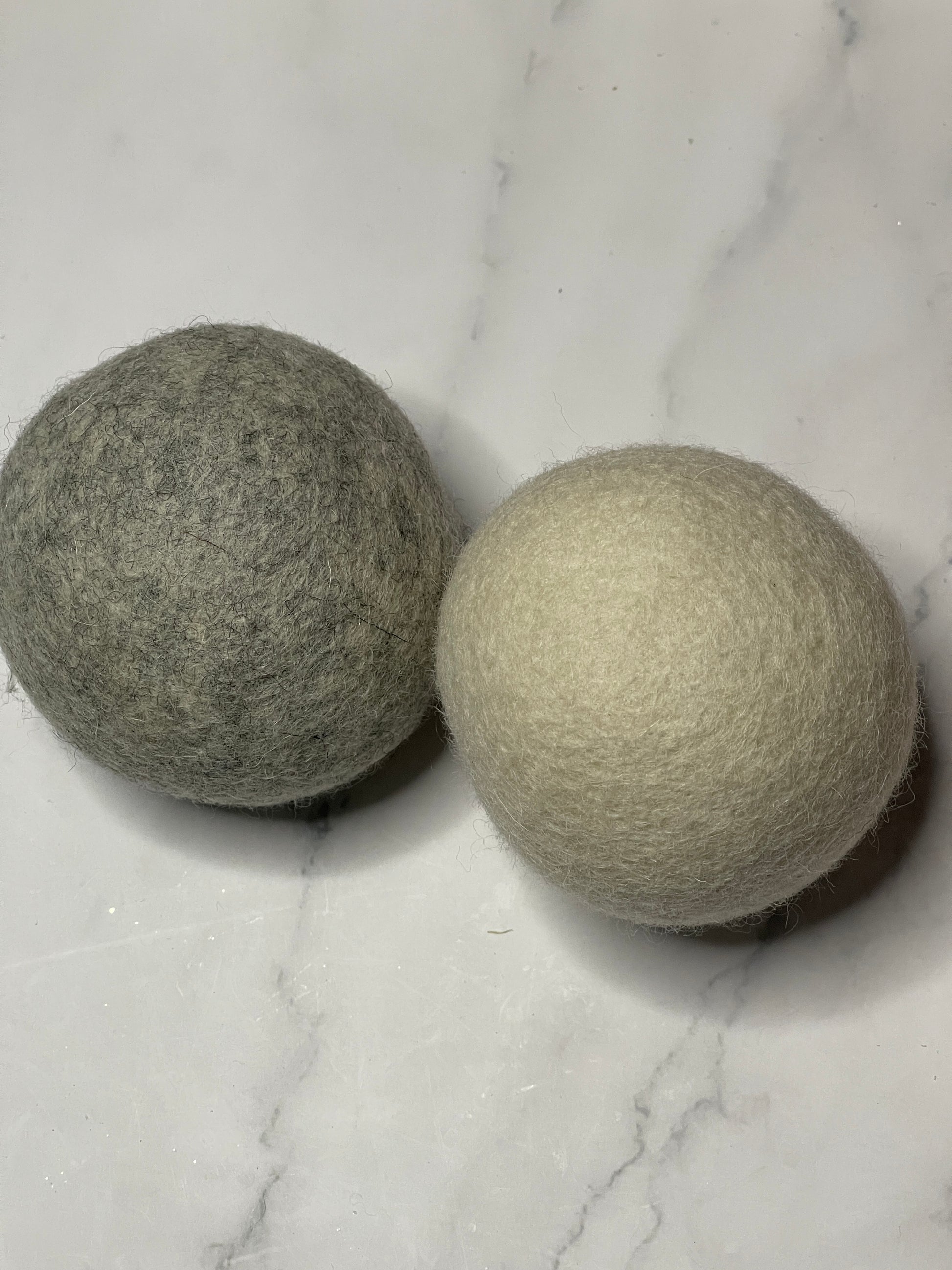 Two gray balls on a marble surface