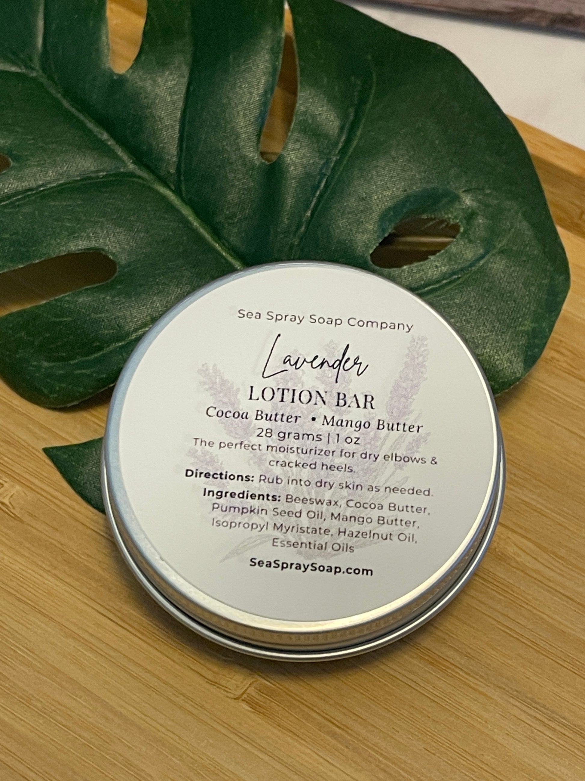 Lavender lotion bar with packaging on a wooden surface