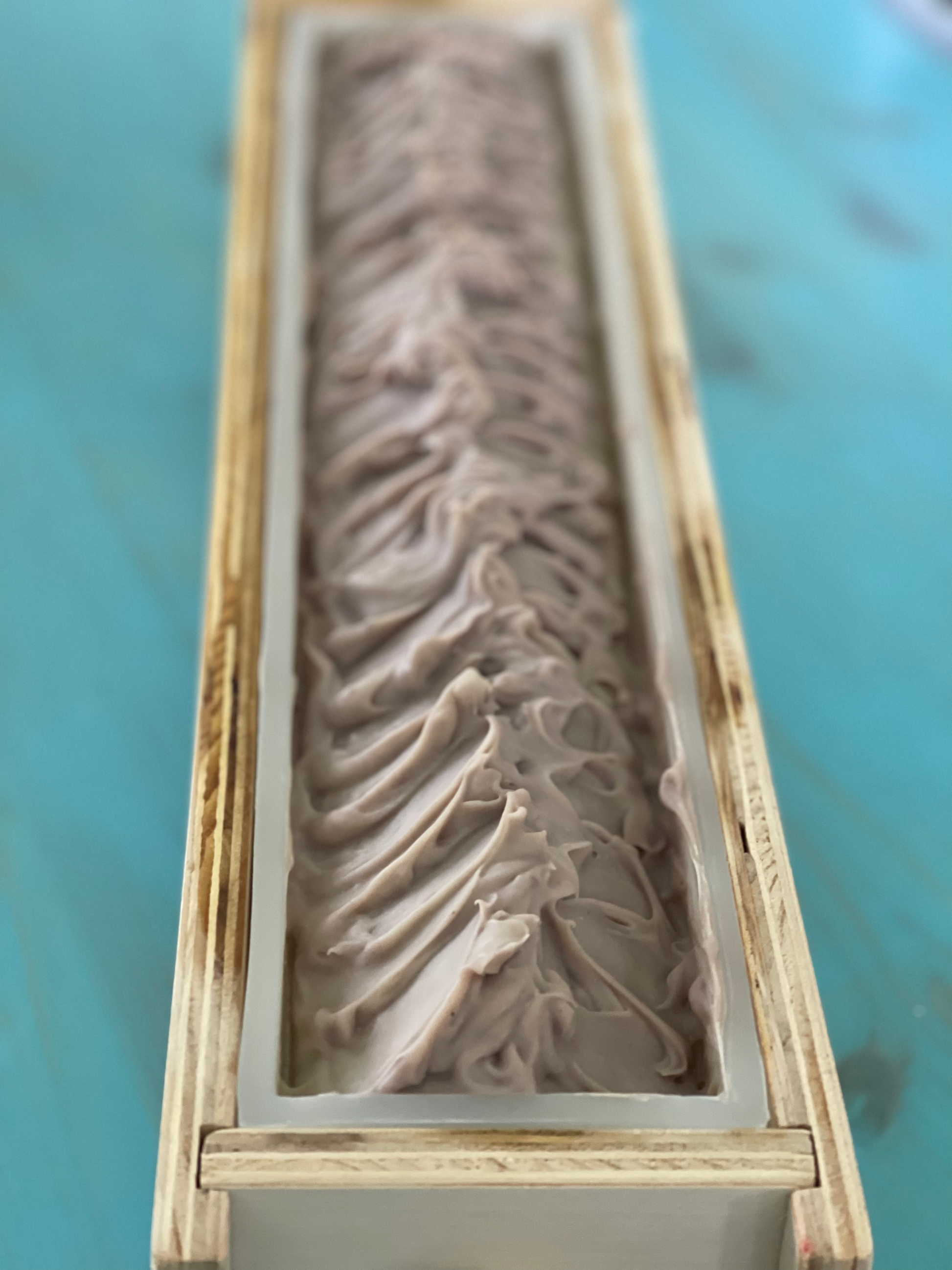 Wooden mold with a detailed leaf pattern on a blue surface