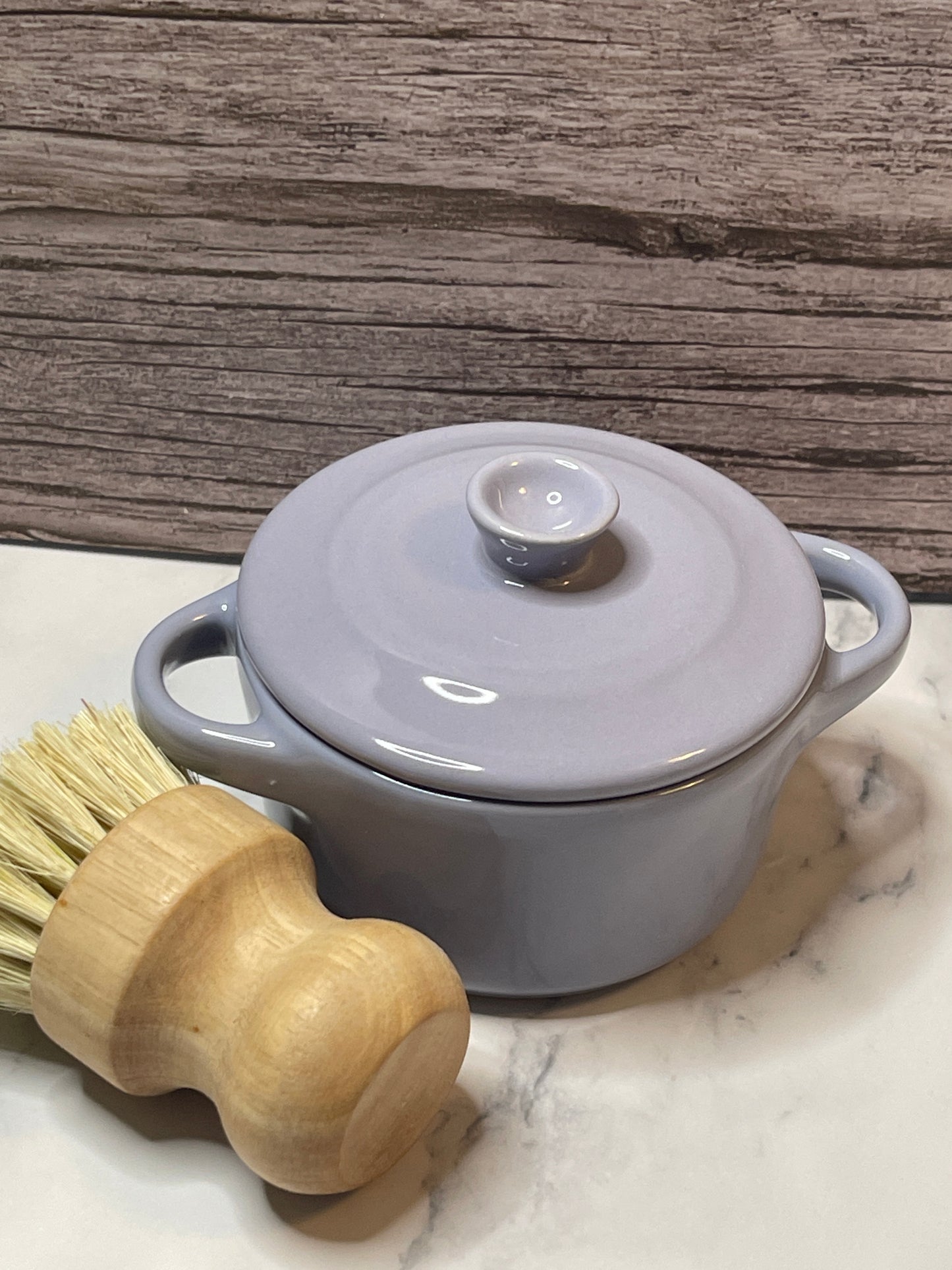 lavender pot with a wooden brush on a marble surface