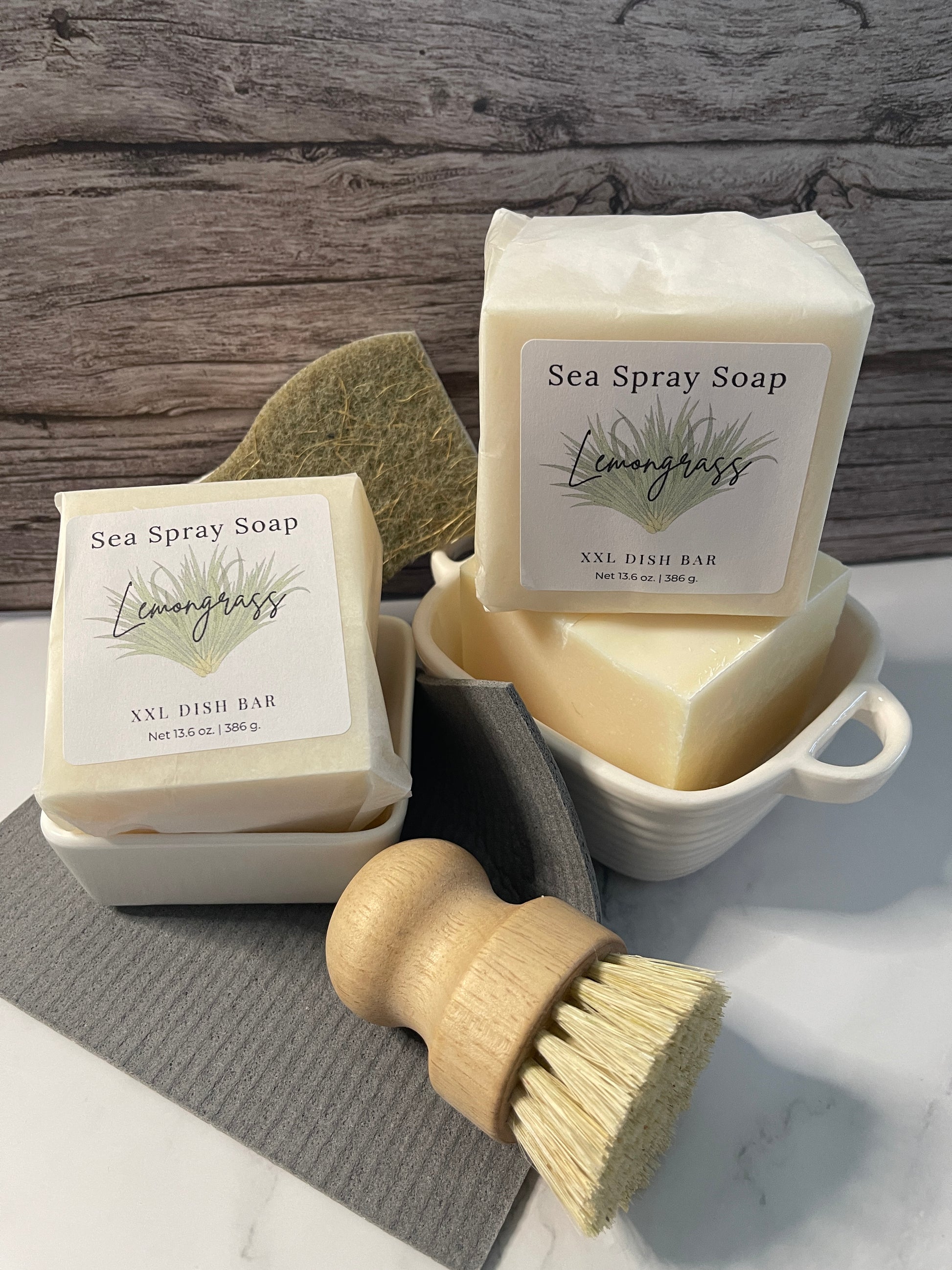 Two bars of Sea Spray Soap with a brush on a wooden surface