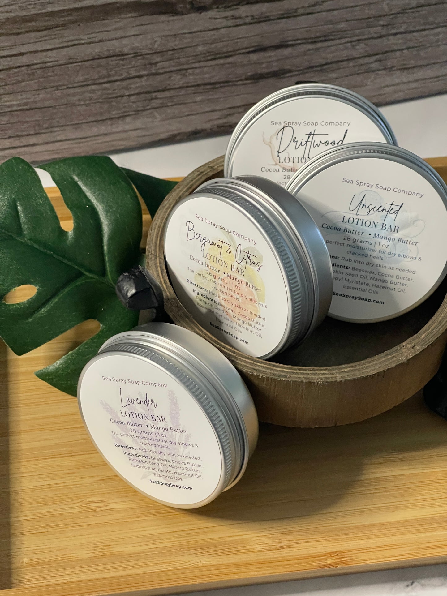 Jars of lotion with labels on a wooden surface