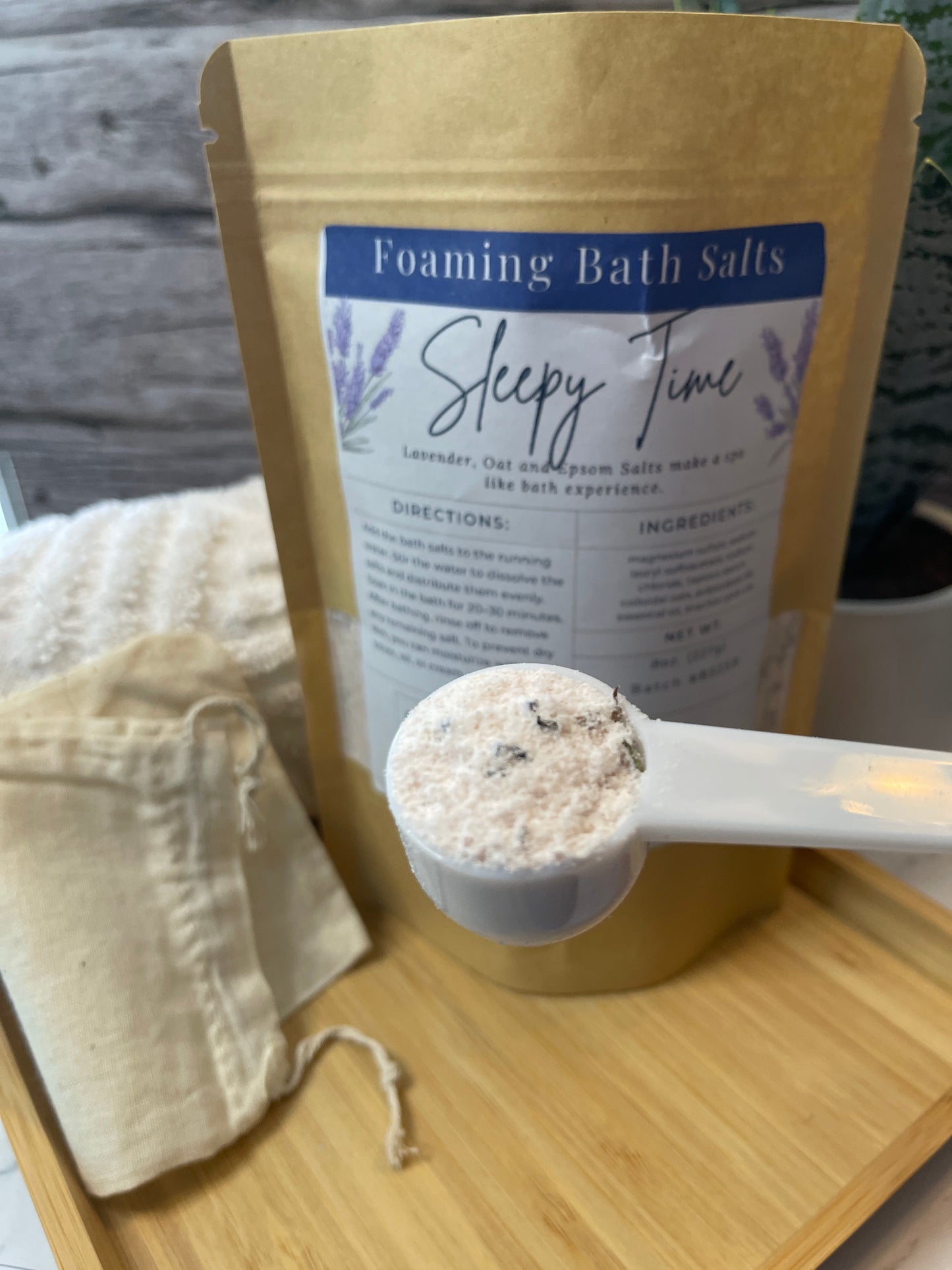 Foaming bath salts with a spoonful on a wooden board