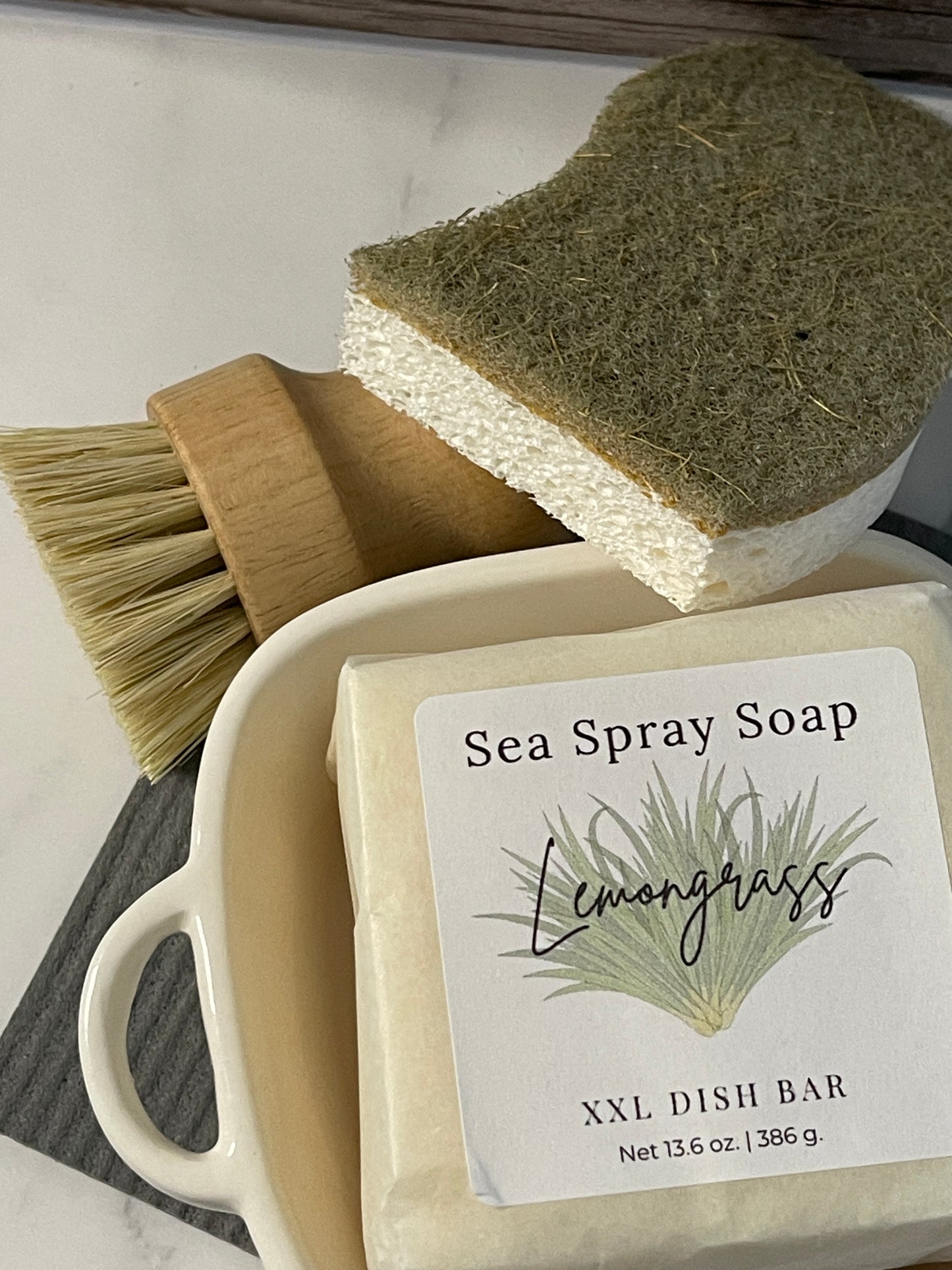 Sea spray soap bar with a brush and sponge on a white surface