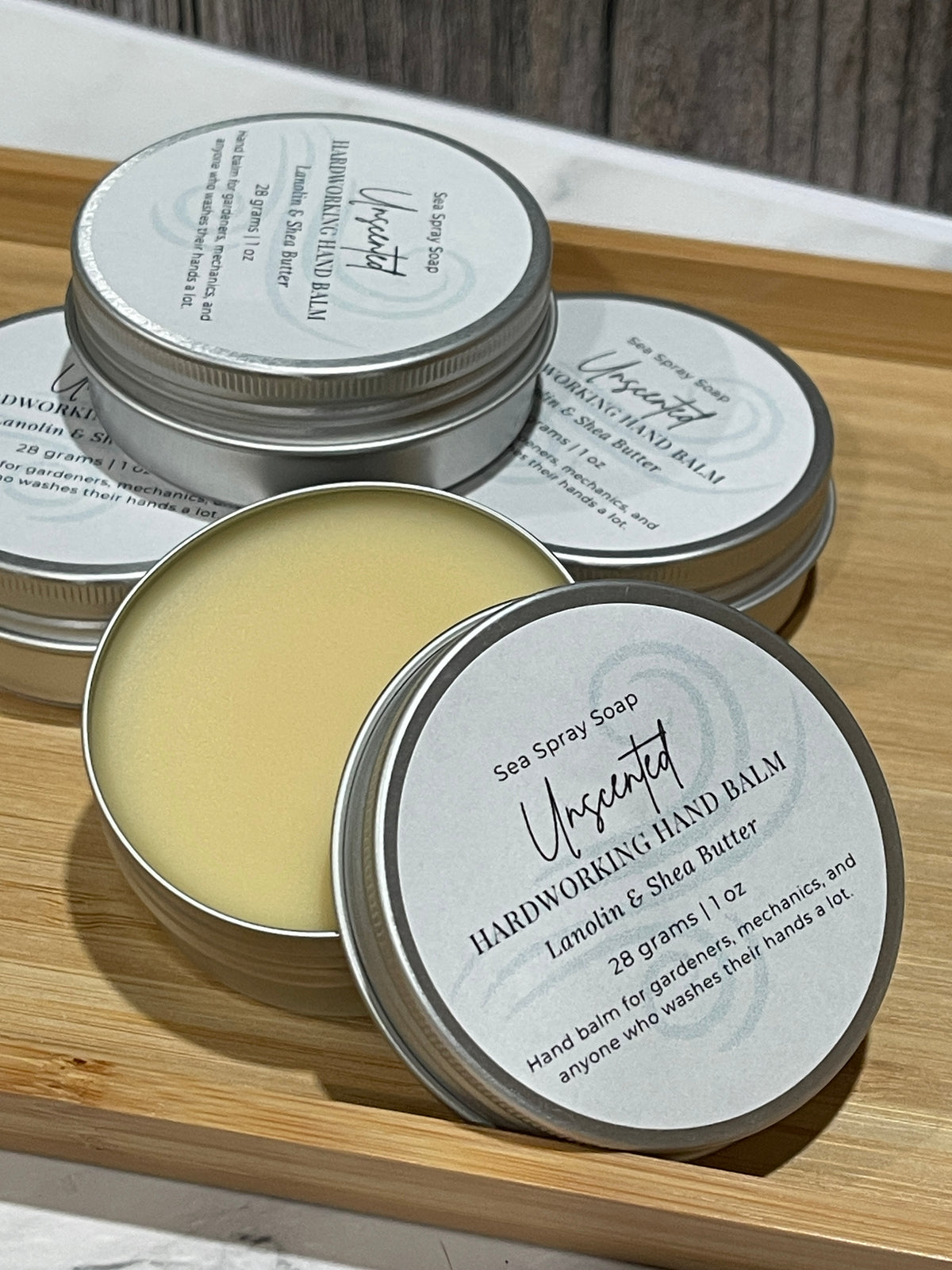 Stack of hardworking hand balm tins in unscented