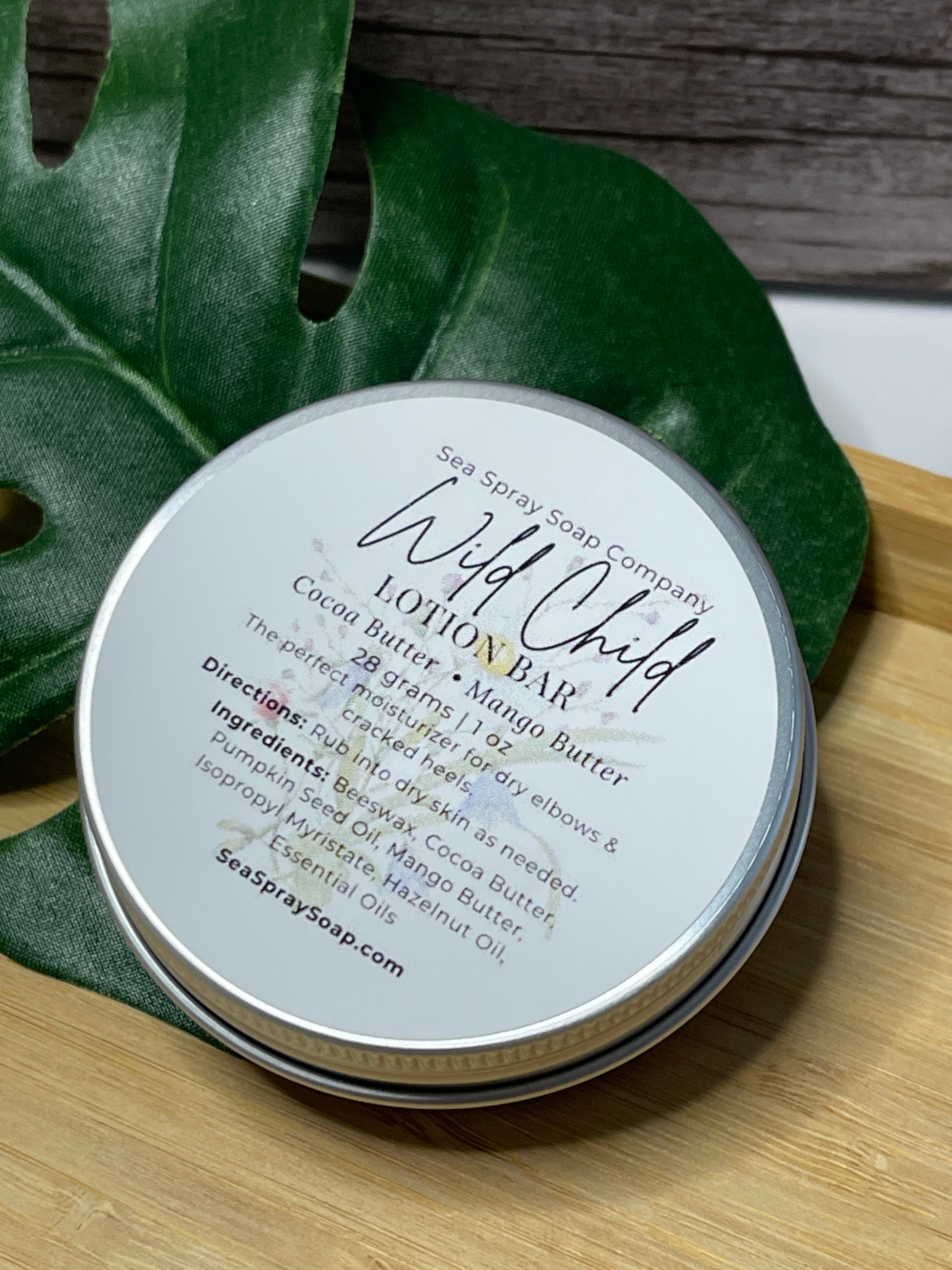 Tin labeled 'Wild Child' on a leaf with a wooden background