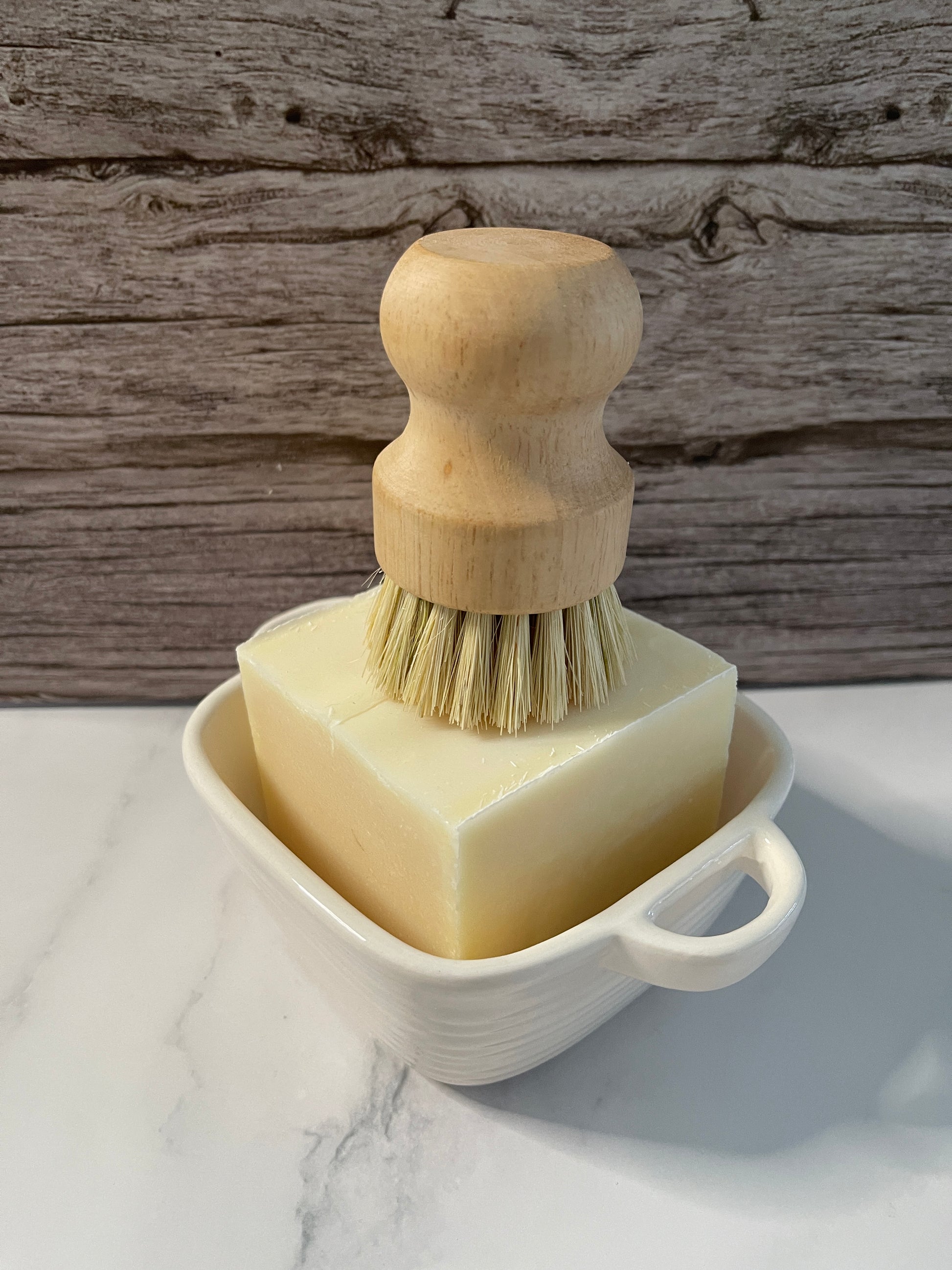 Wooden brush with bristles in a white container on a wooden surface