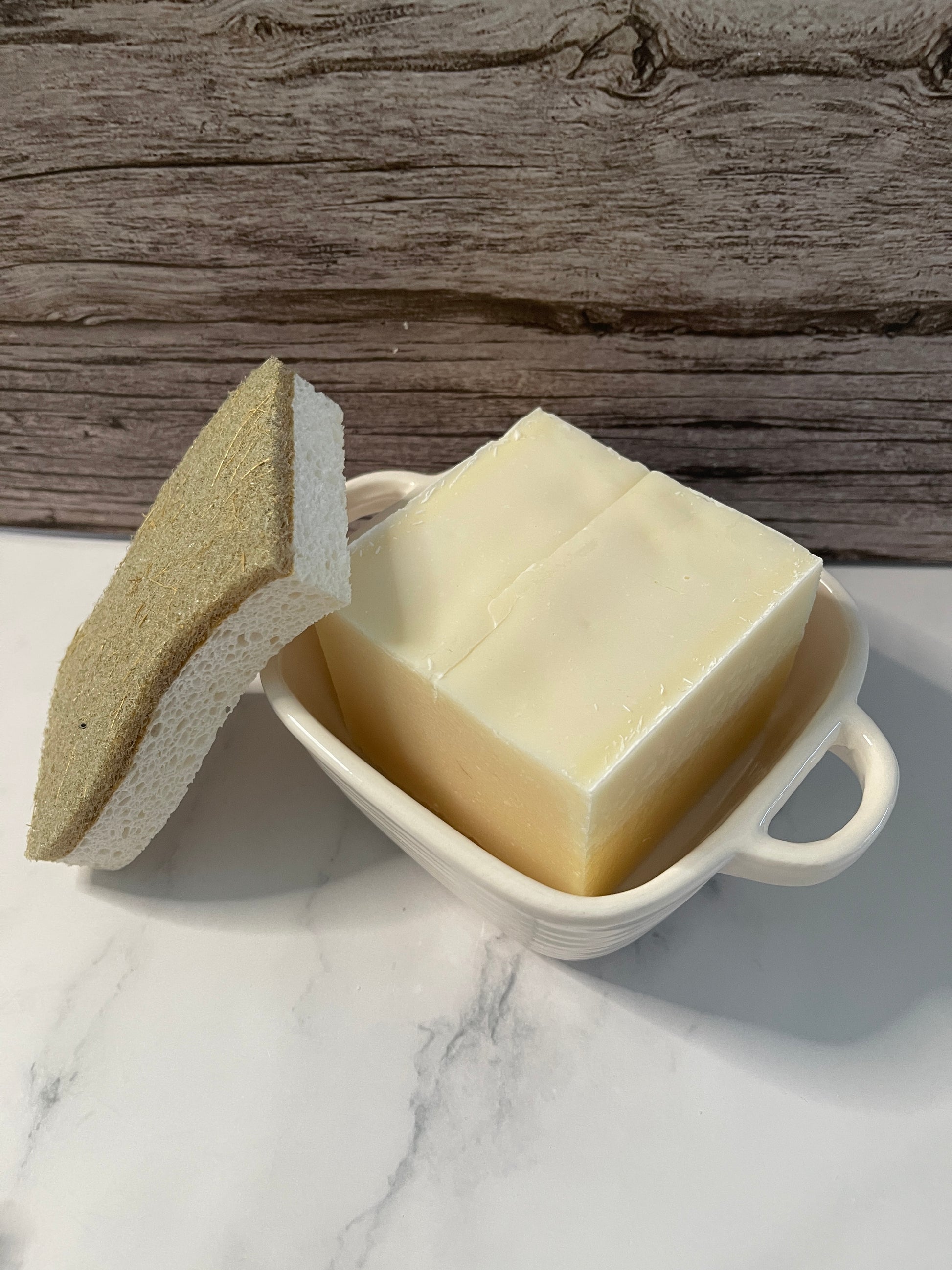 Butter bar with a knife on a marble surface next to a wooden board