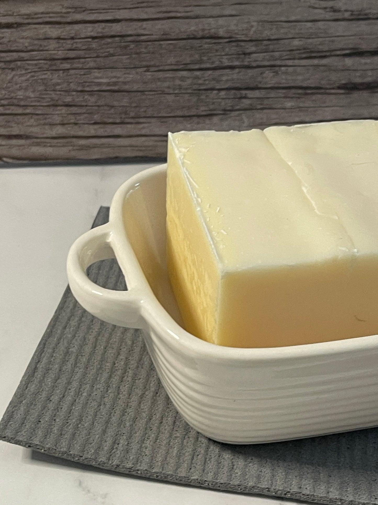 White ceramic dish with a handle on a wooden surface