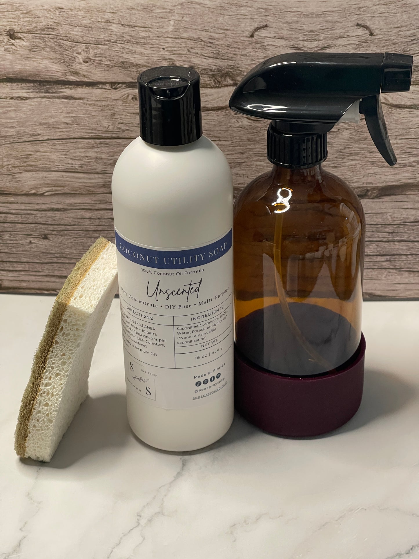 Two bottles with black sprayer nozzles on a wooden surface and white marble background