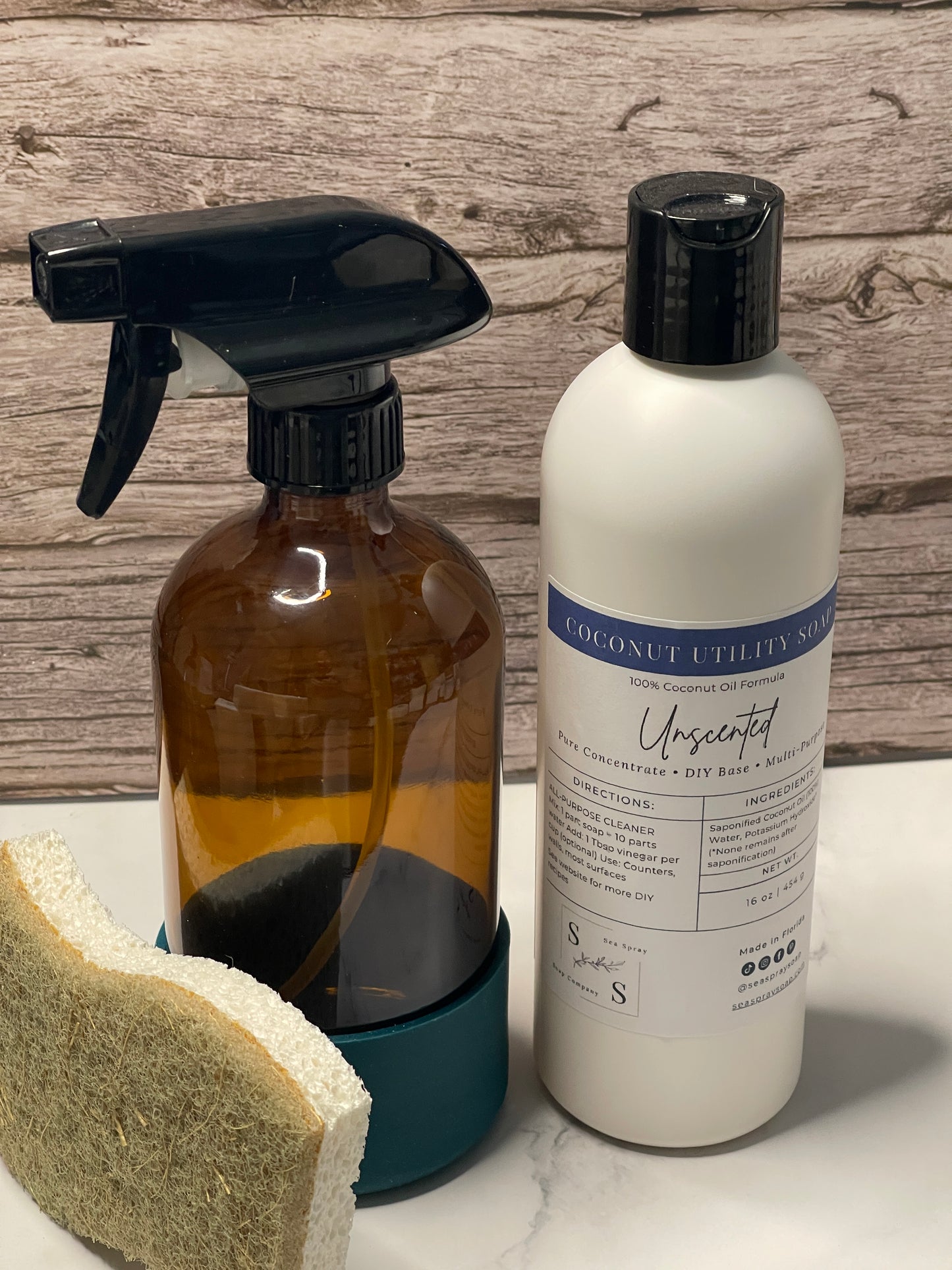 Two bottles and a sponge on a wooden surface