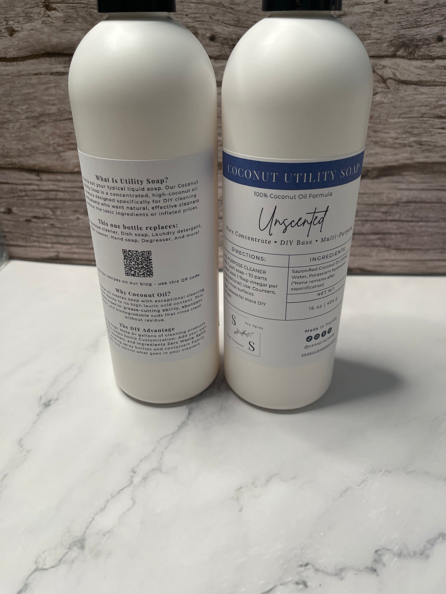 Two white bottles with labels on a marble surface