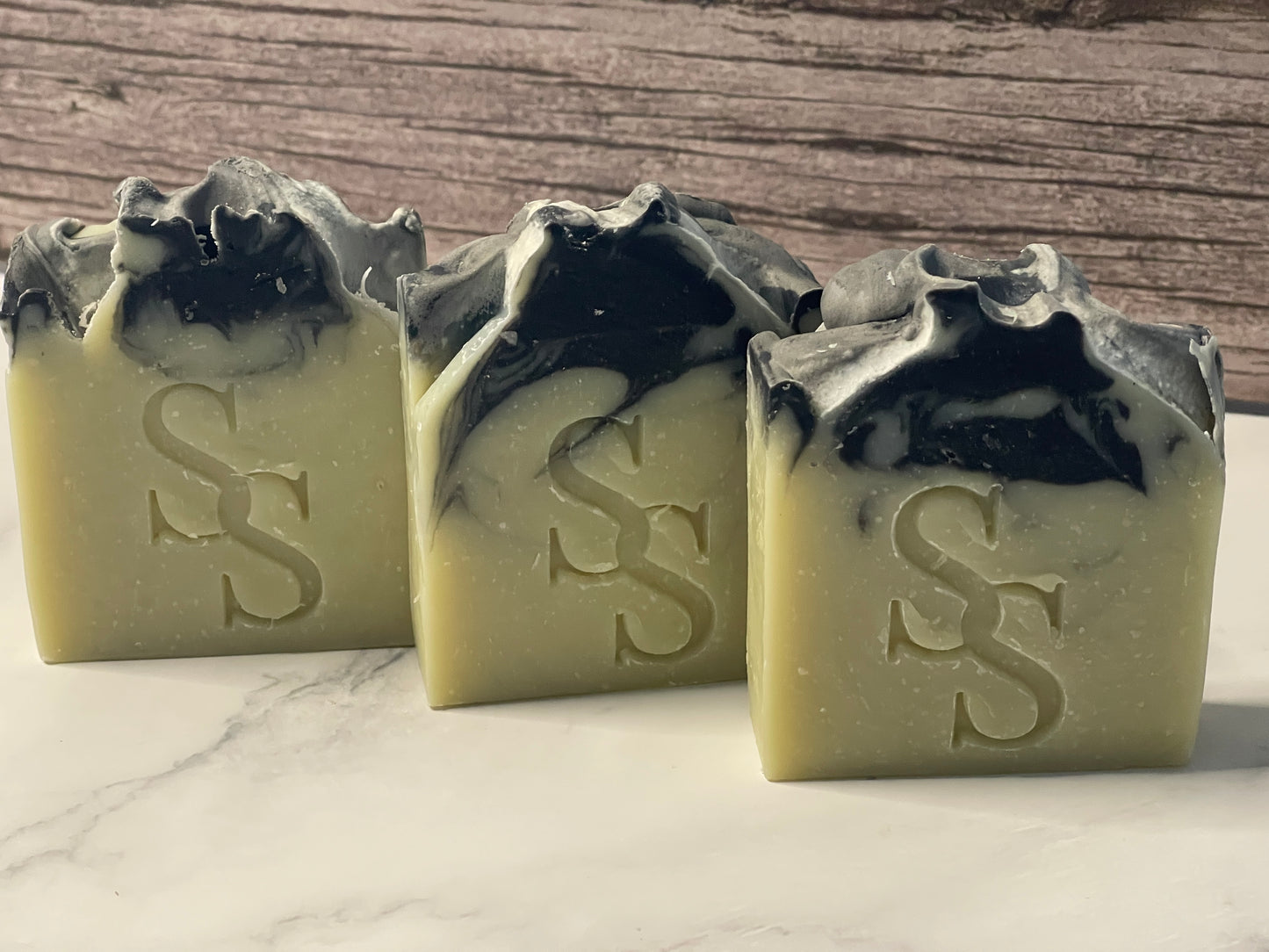 Three bars of soap with a marbled background