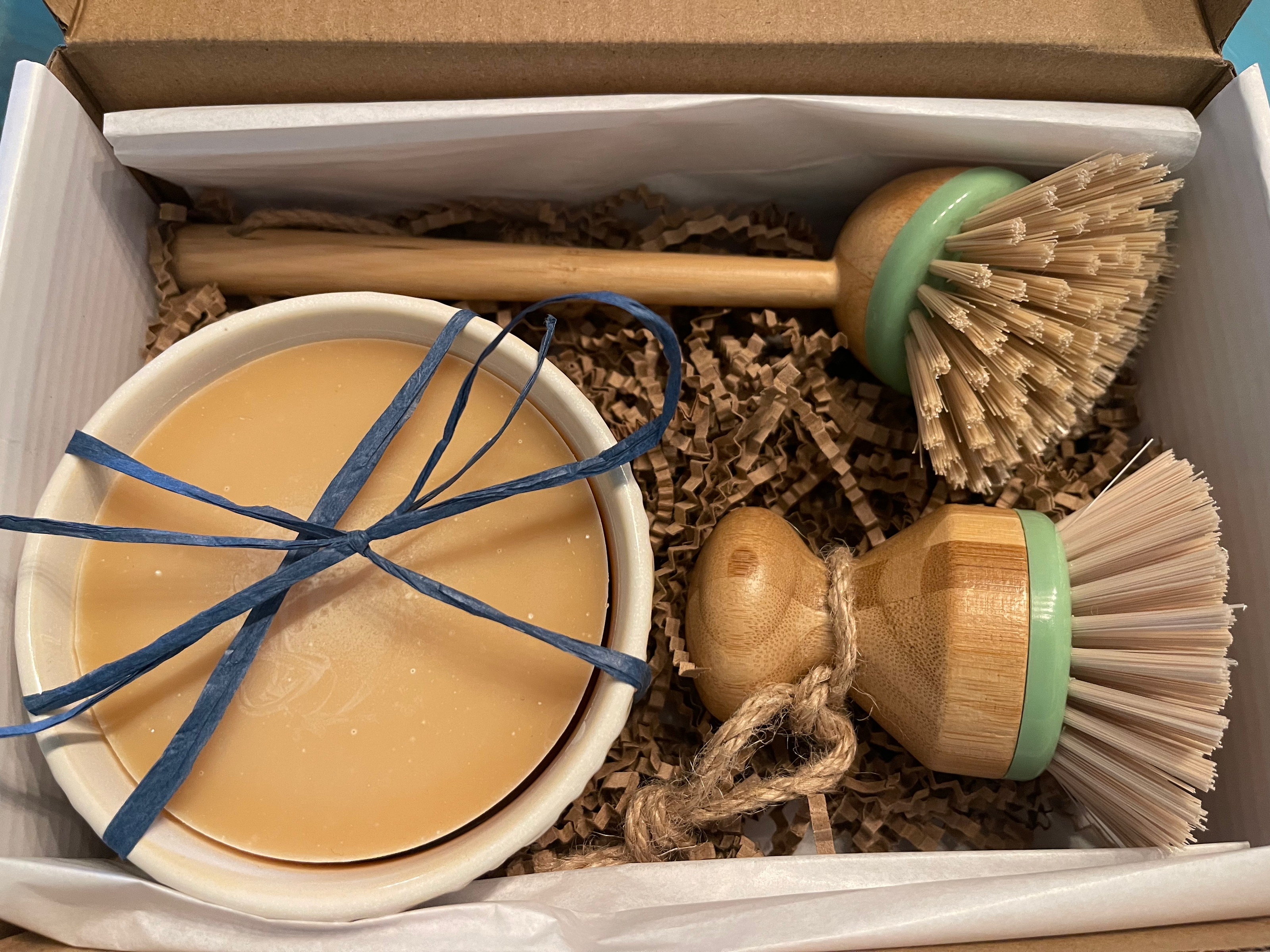 Set of cleaning brushes and a bowl with a liquid product in a box