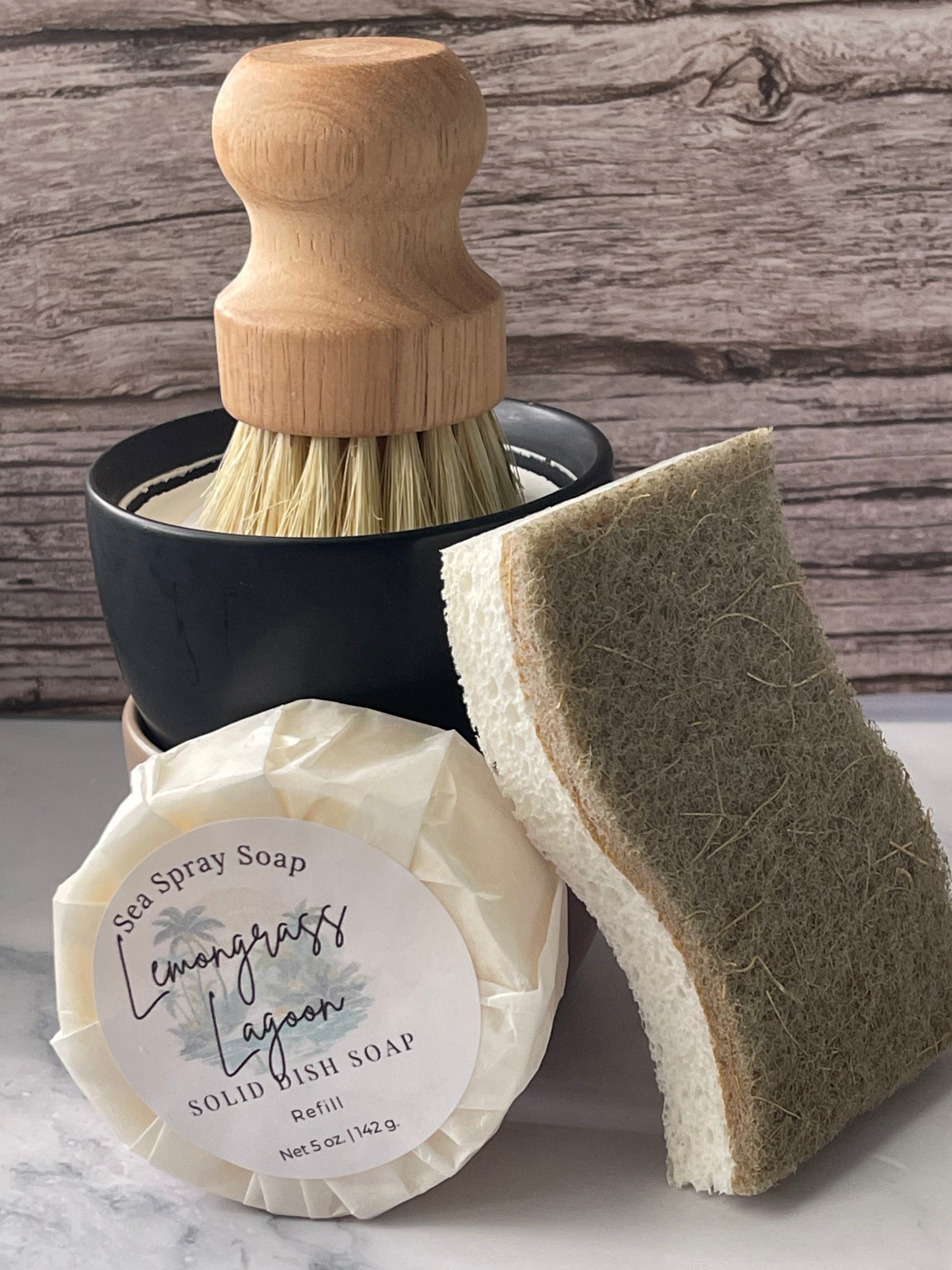 Cleaning brush, sponge, and bar of soap on a wooden surface