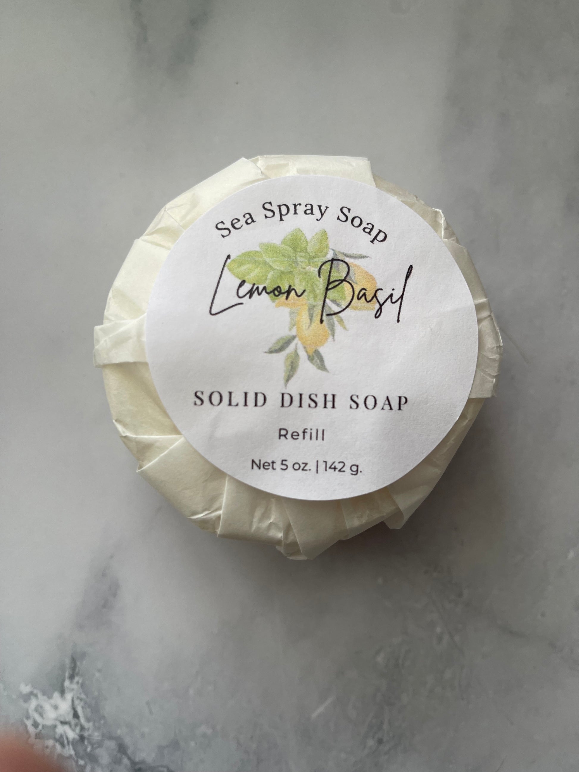 Solid dish soap bar with a label on a gray surface