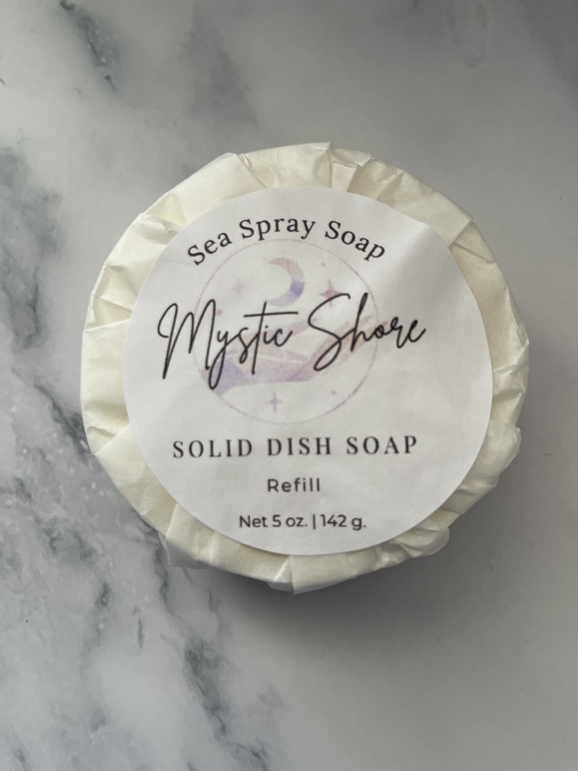 Solid dish soap refill labeled 'Mystic Shore' on a marble background