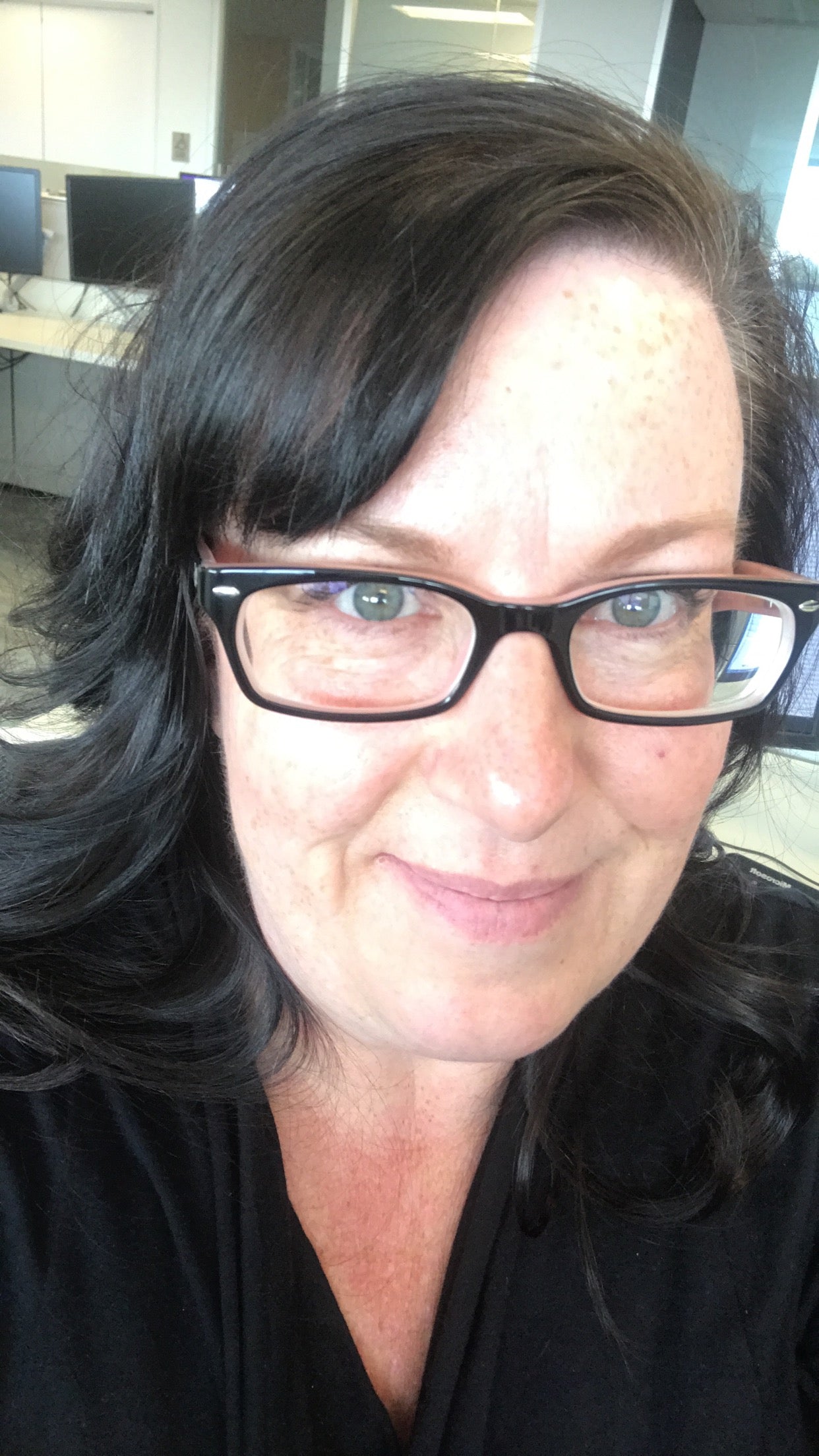 Person wearing glasses with a blurred indoor background