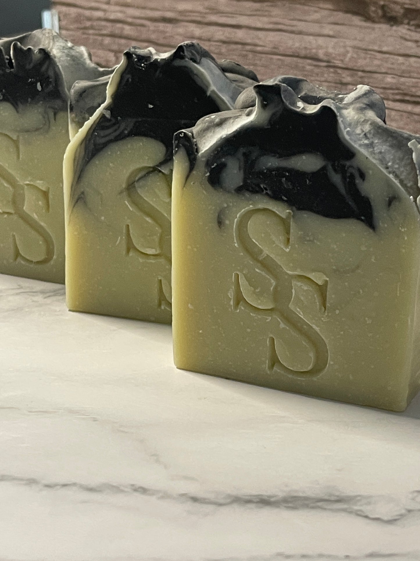 Two soap bars with a logo on a marble surface