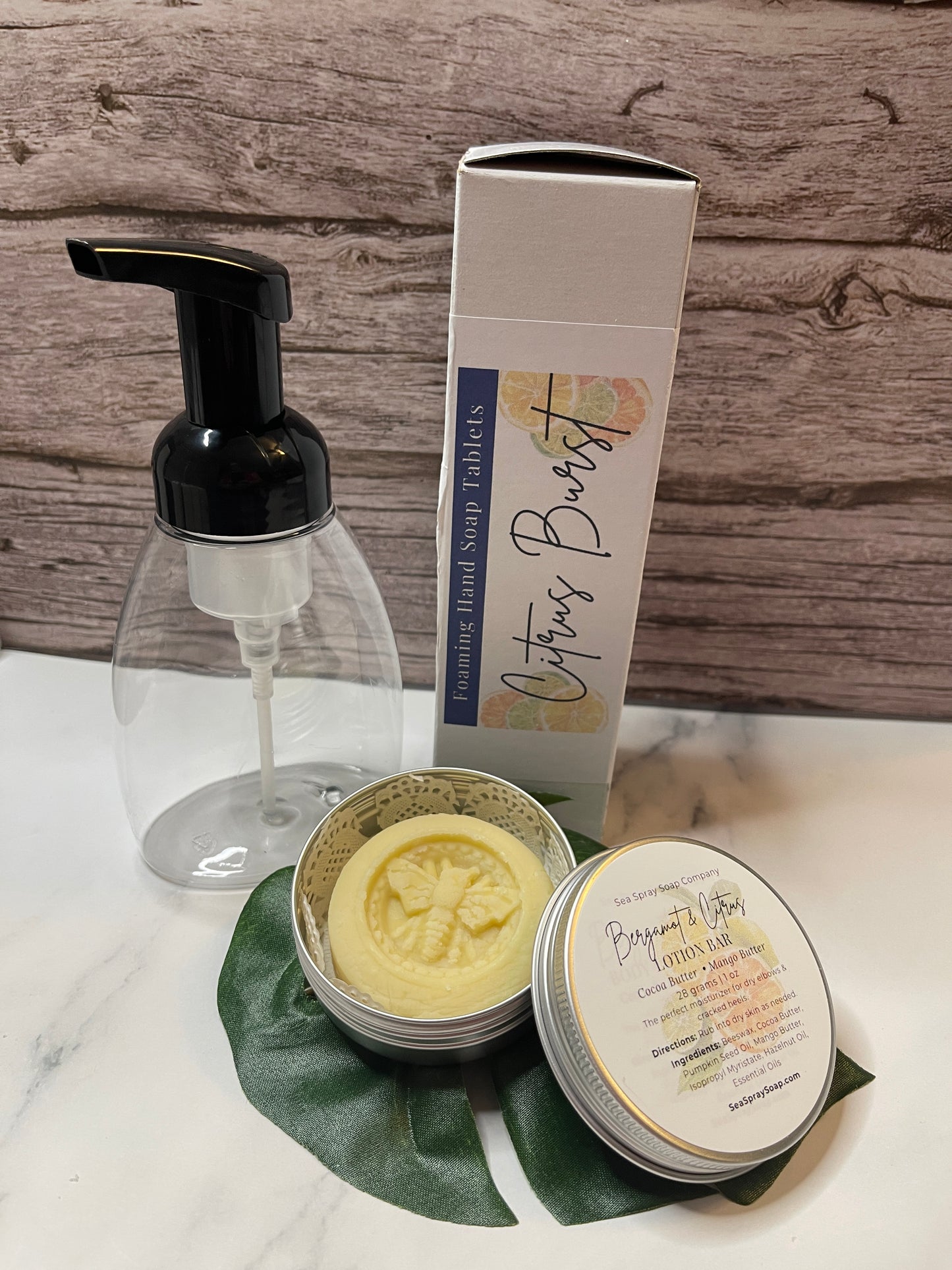 Soap dispenser, soap bars, and packaging on a wooden surface