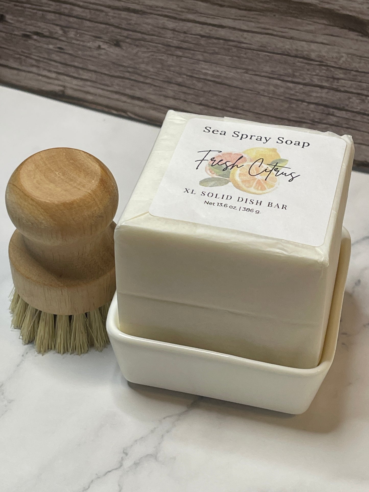 Bar of soap with a wooden brush on a marble surface