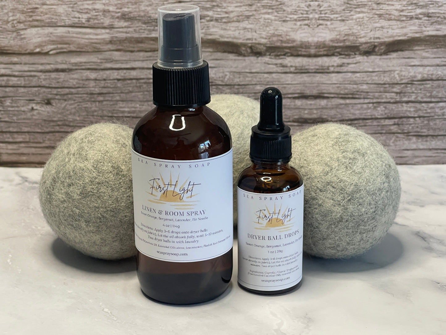 Two bottles of 'First Light' products on a marble surface with wooden background
