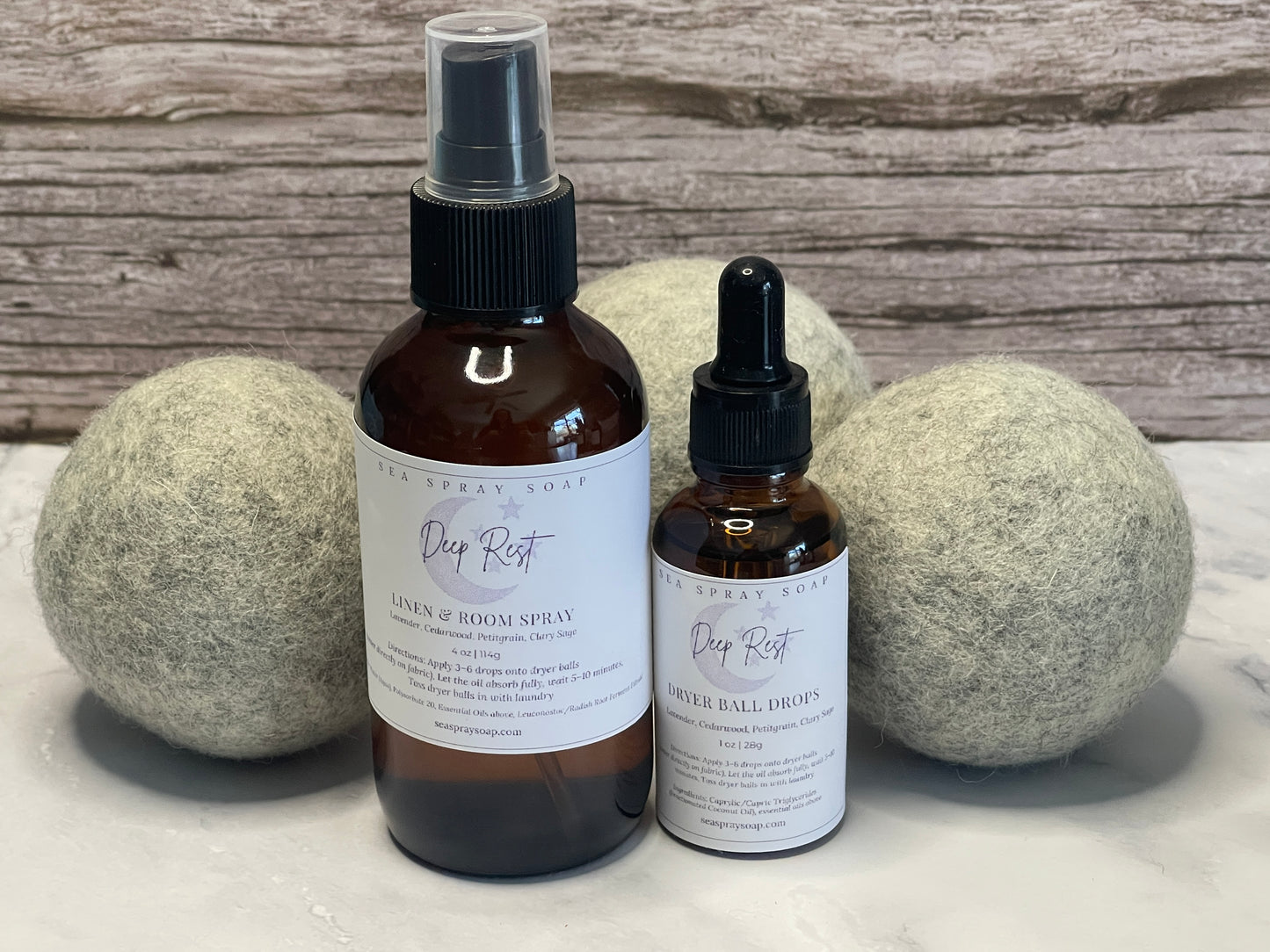 Two bottles of 'Deep Rest' products with labels on a marble surface with wooden background