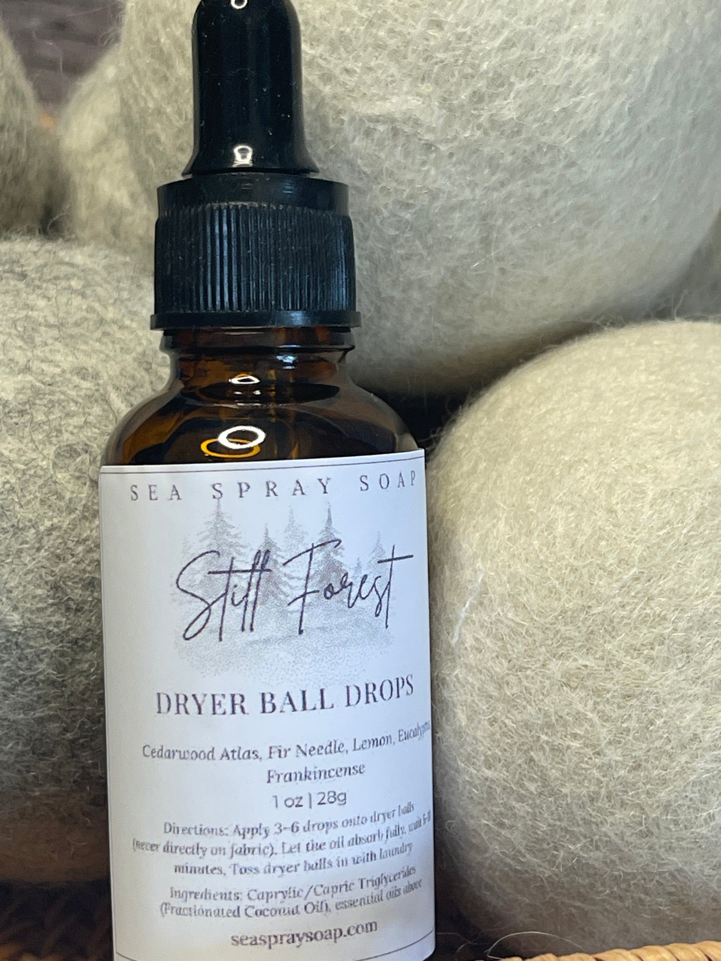 Bottle of Sea Spray Soap Co. dryer ball drops on a textured surface