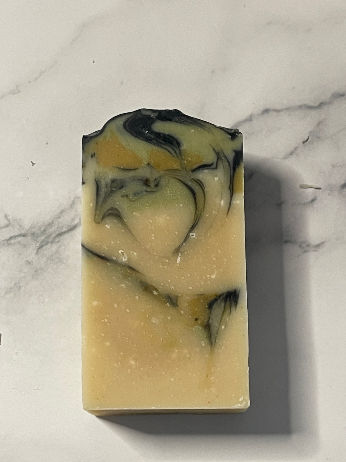 Bar of soap with black and white swirls on a marble surface