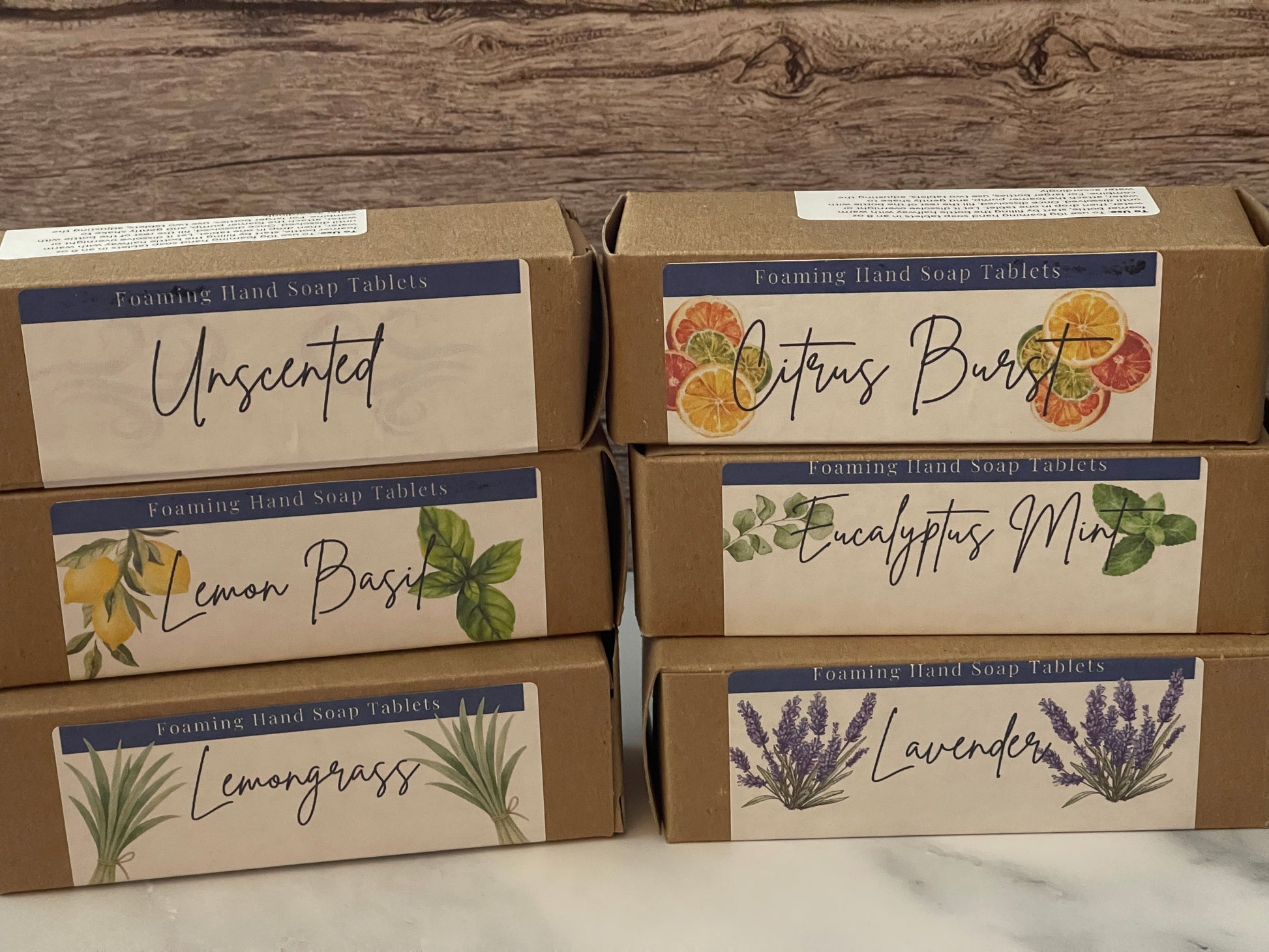 Boxes of hand soap tablets with various scents on a wooden surface