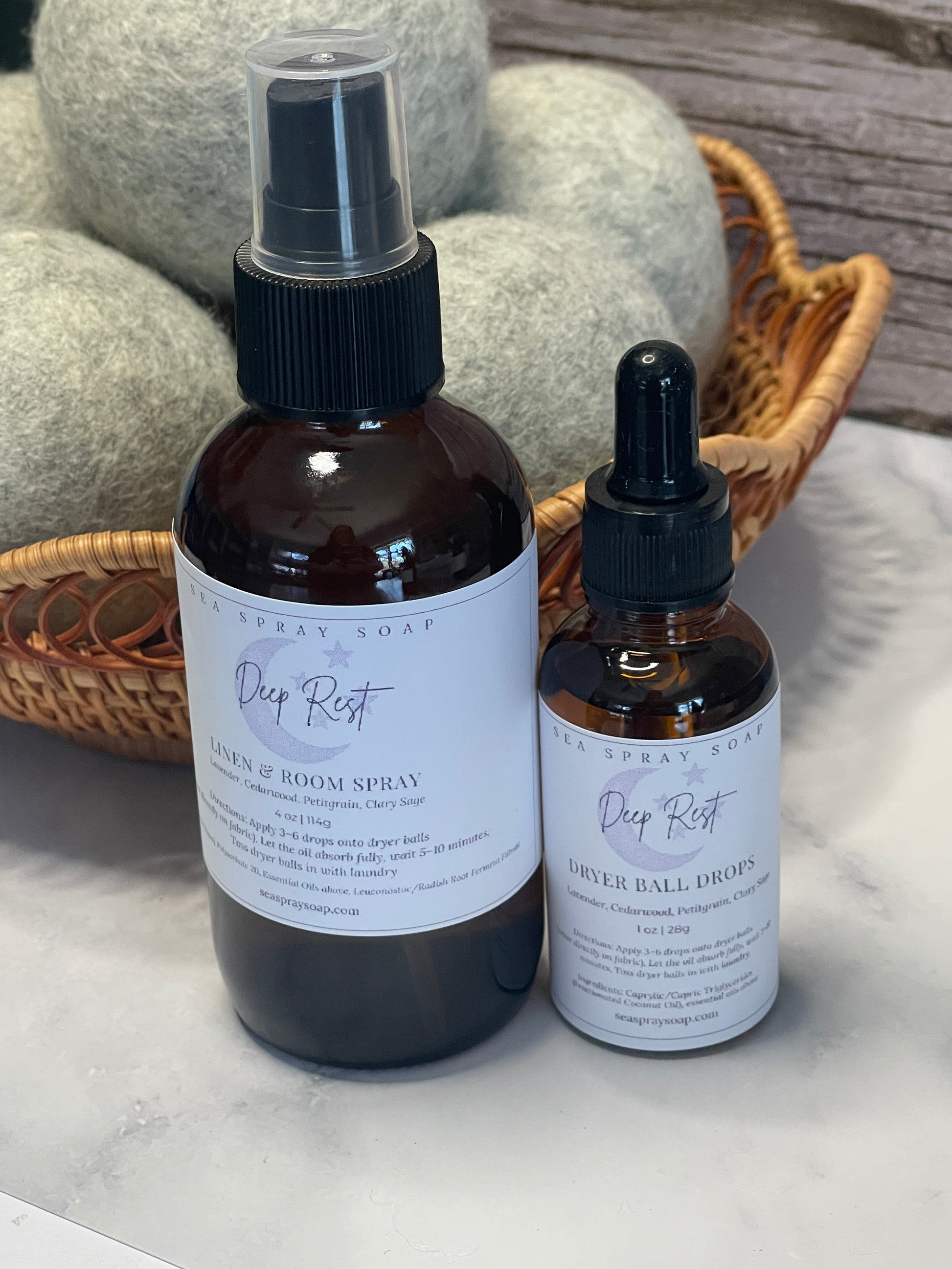 Two bottles with dropper and spray mechanisms on a textured surface