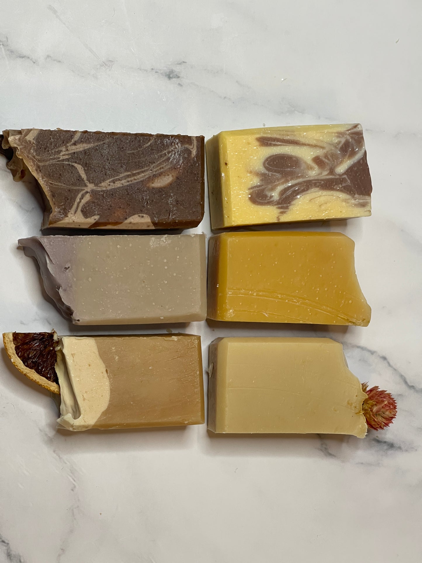 Six different bars of soap on a marble surface