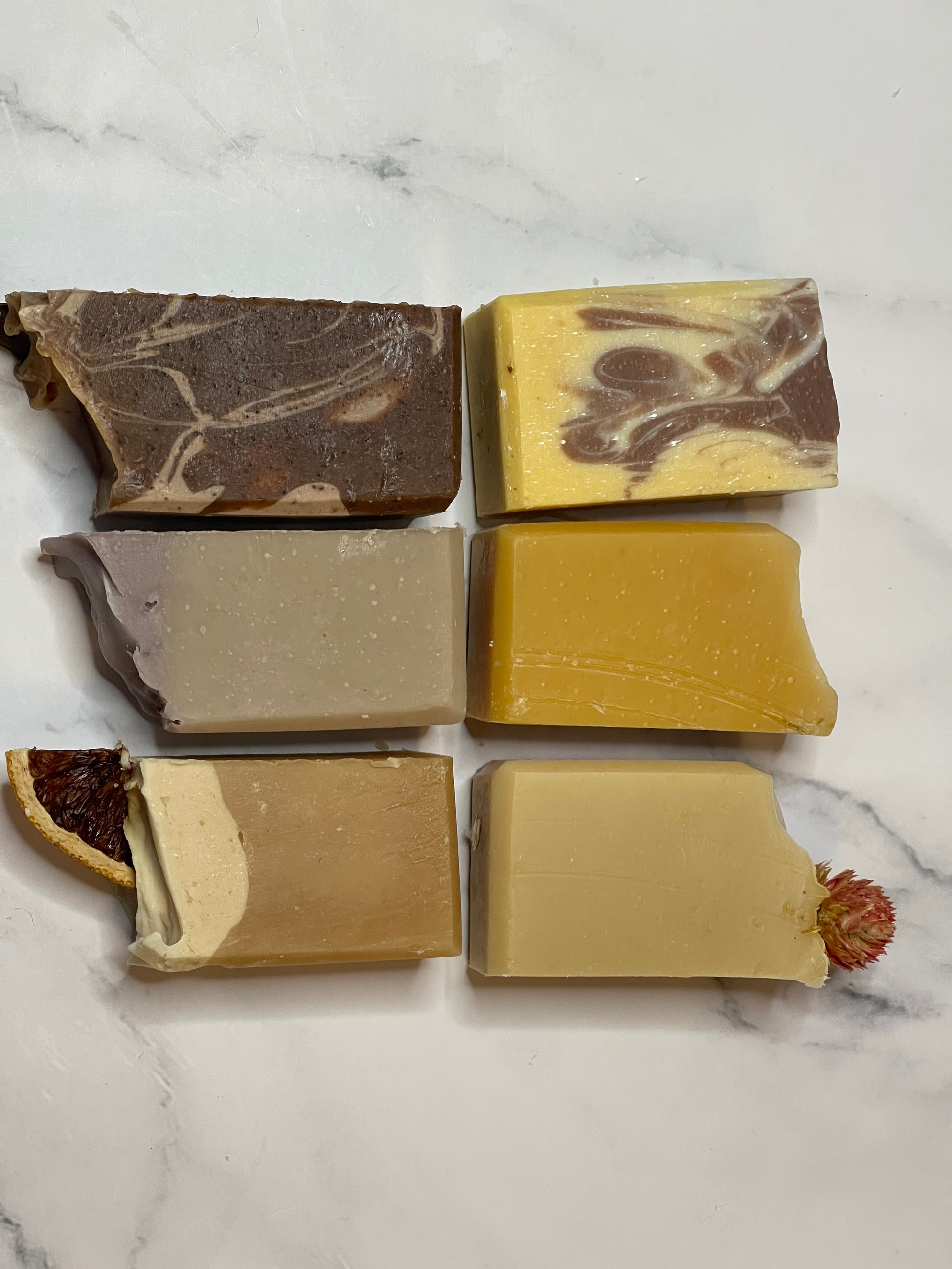 Six different bars of soap on a marble surface