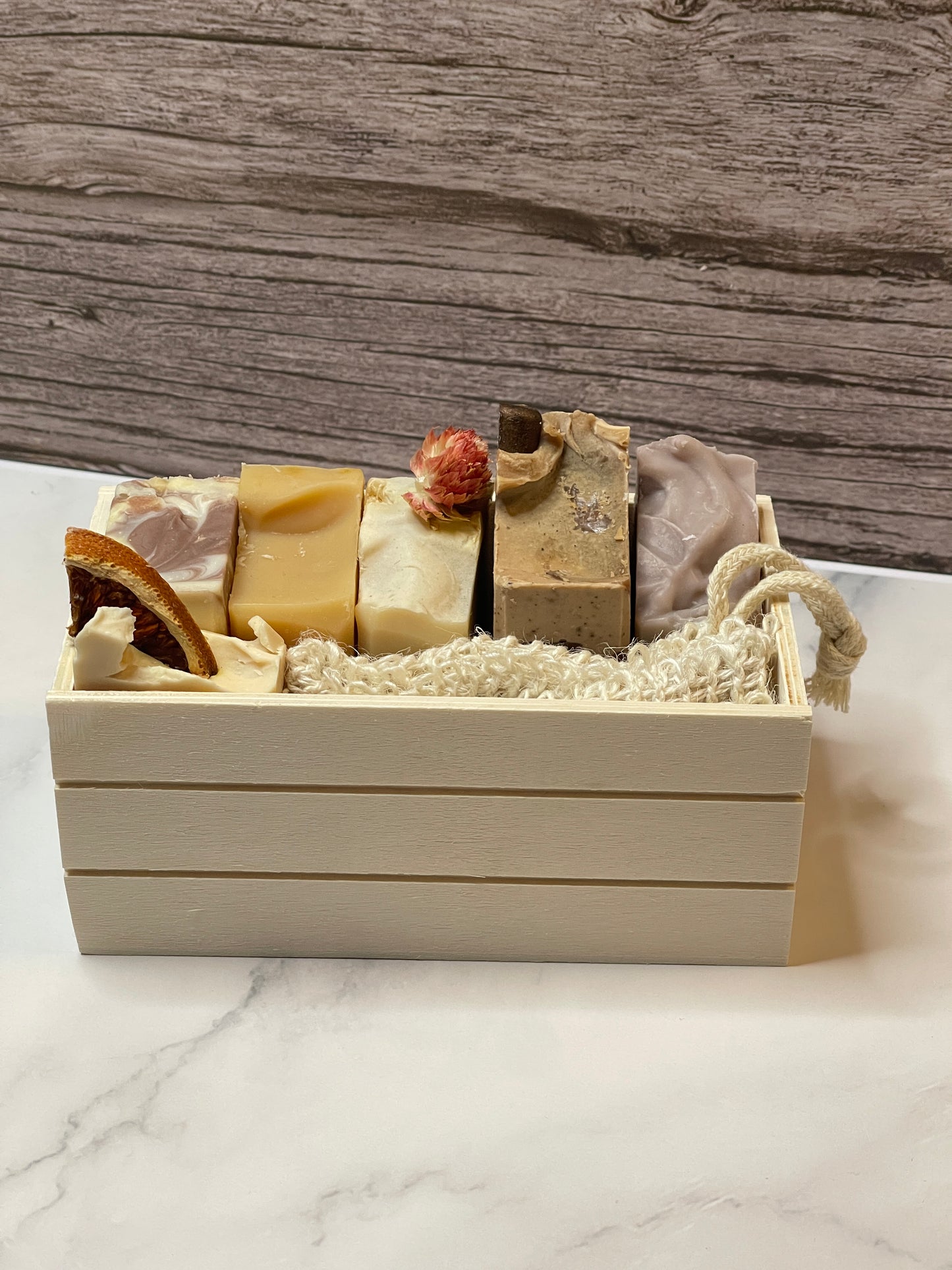 Set of soap bars in a wooden box with a textured background