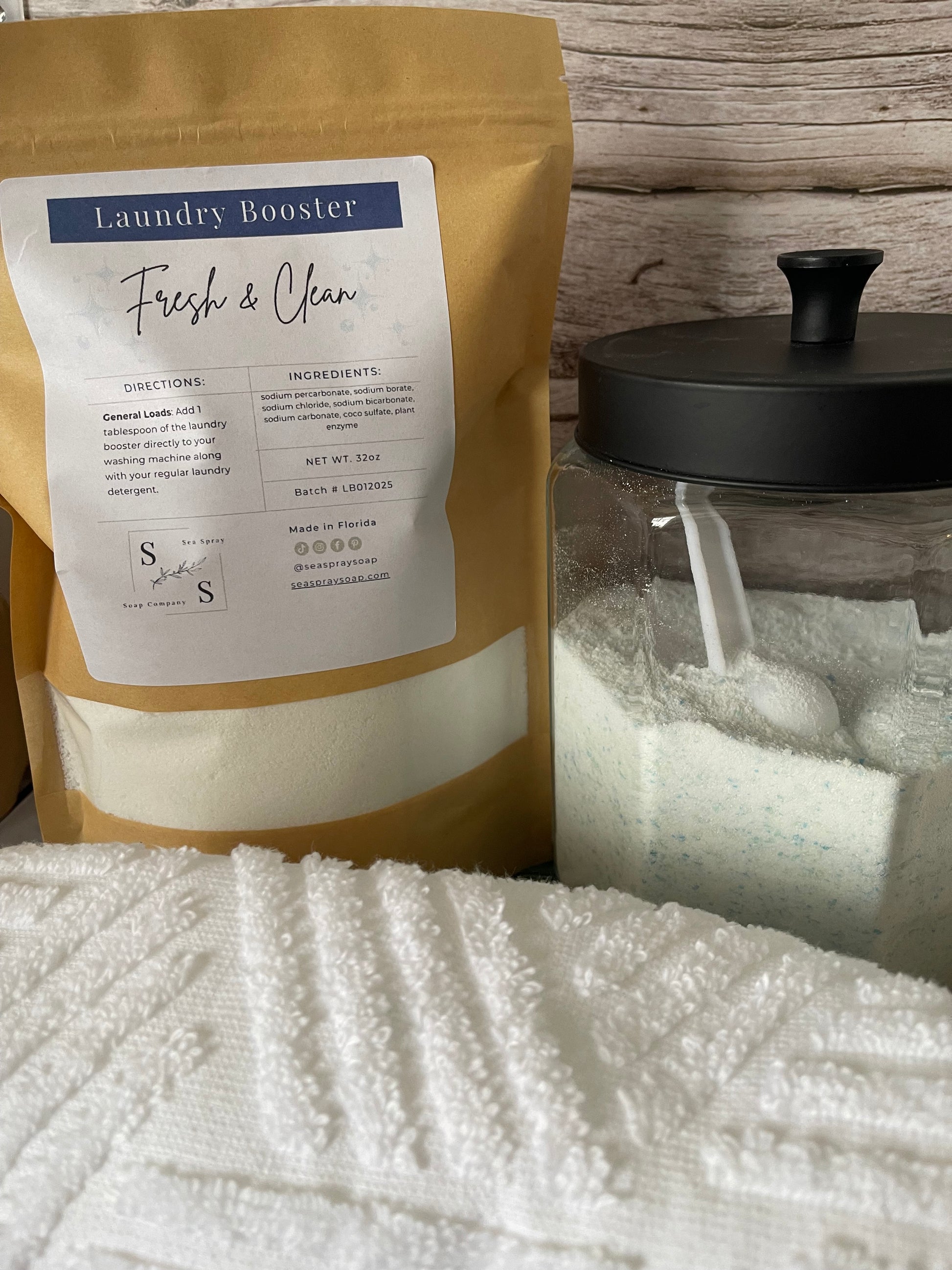 Laundry booster package on a wooden surface with a towel in the background