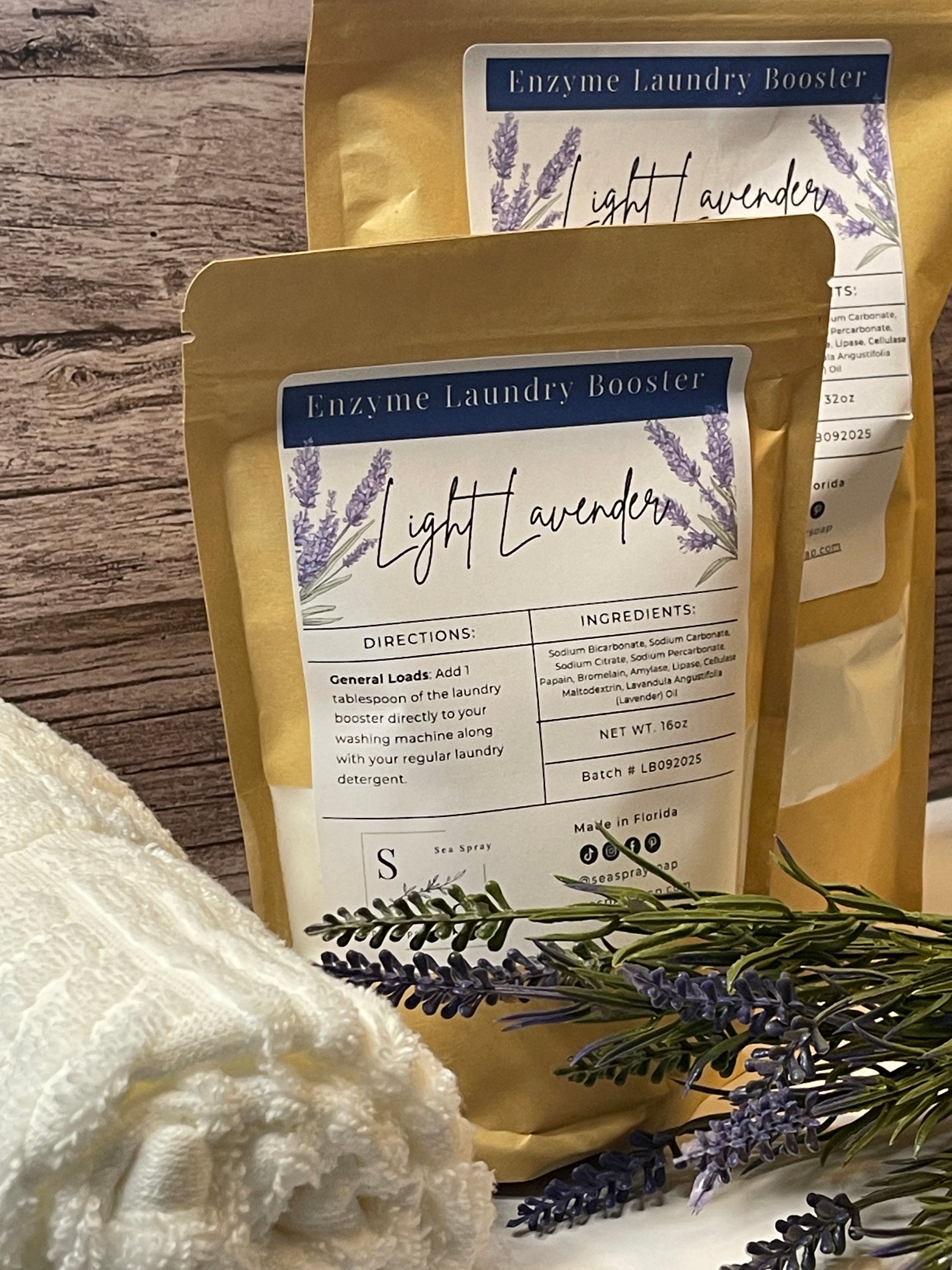 Two packages of Light Lavender laundry booster with lavender flowers on a wooden surface.
