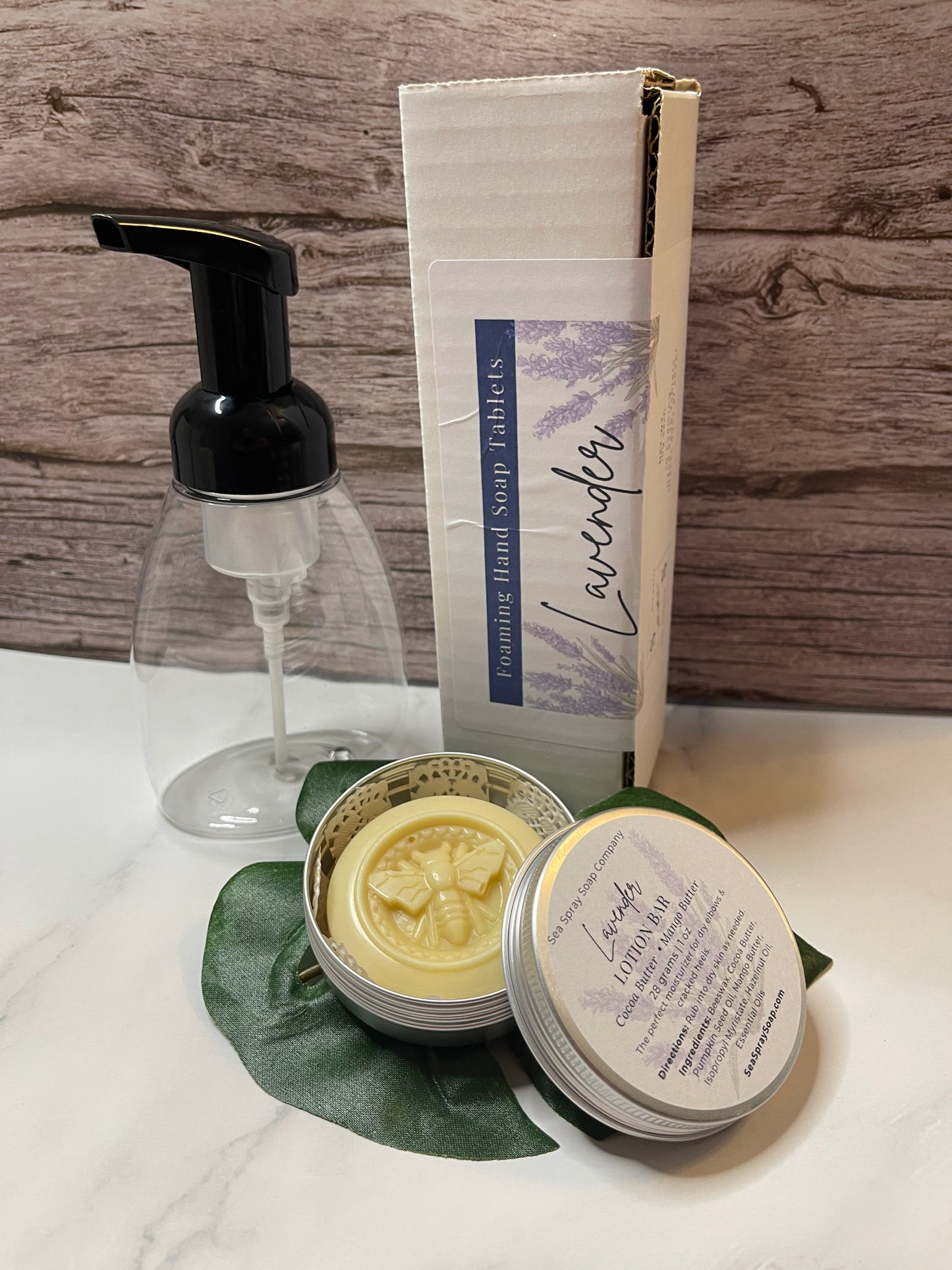Cosmetic product with pump, container of soap, and soap bar on a wooden surface.