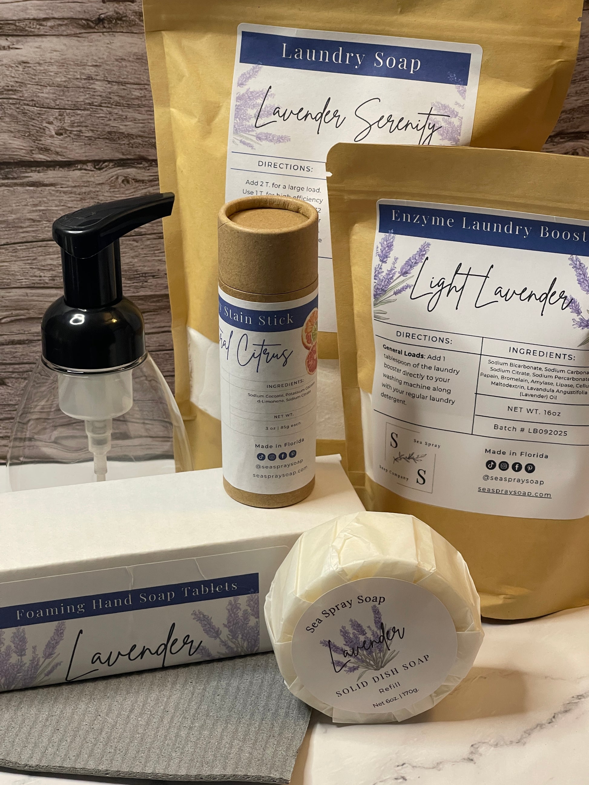 Collection of laundry products including bags, bottles, and a bar of soap on a wooden surface.