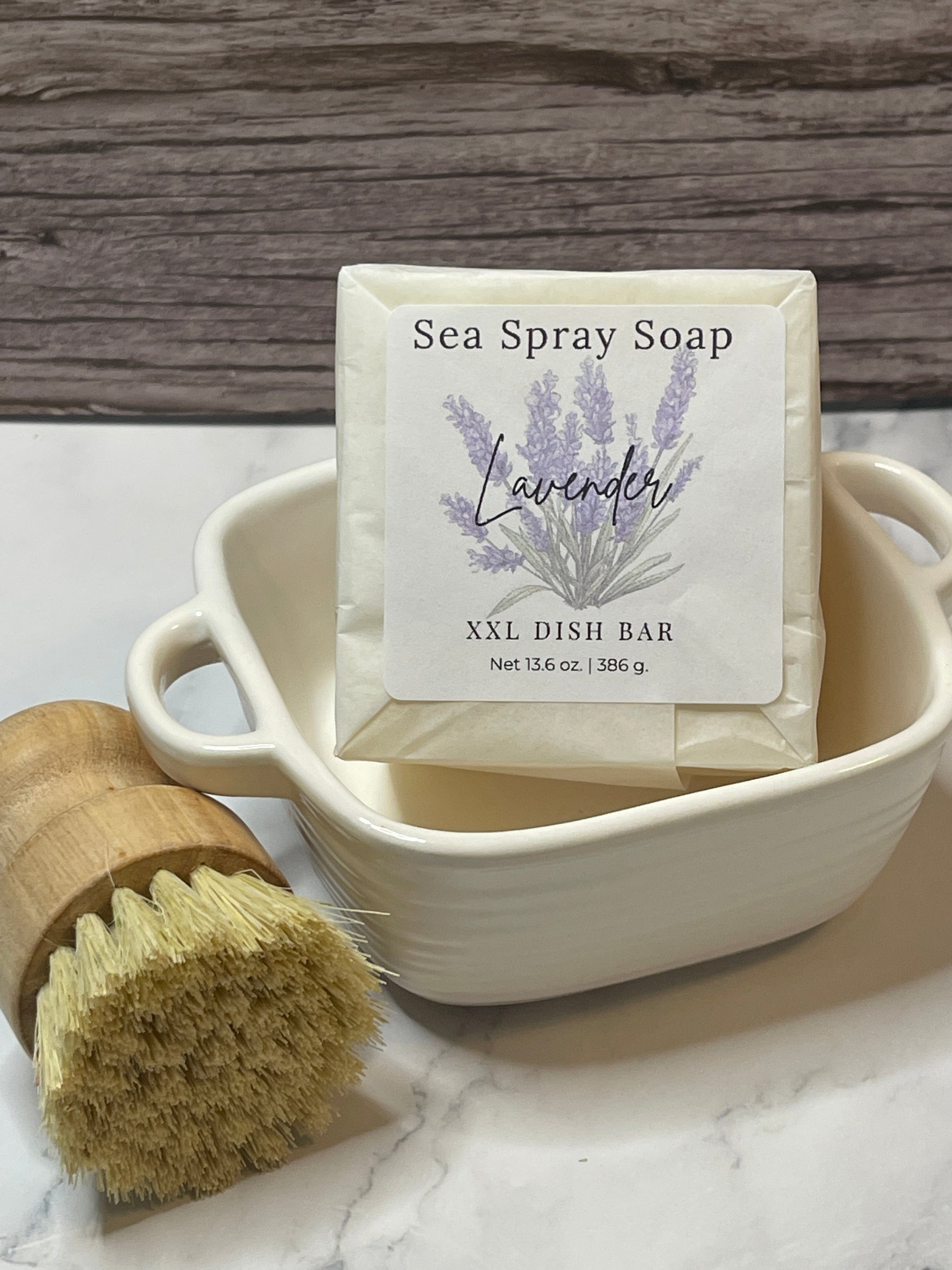 Sea Spray Soap bar with lavender scent in a white container on a wooden surface.
