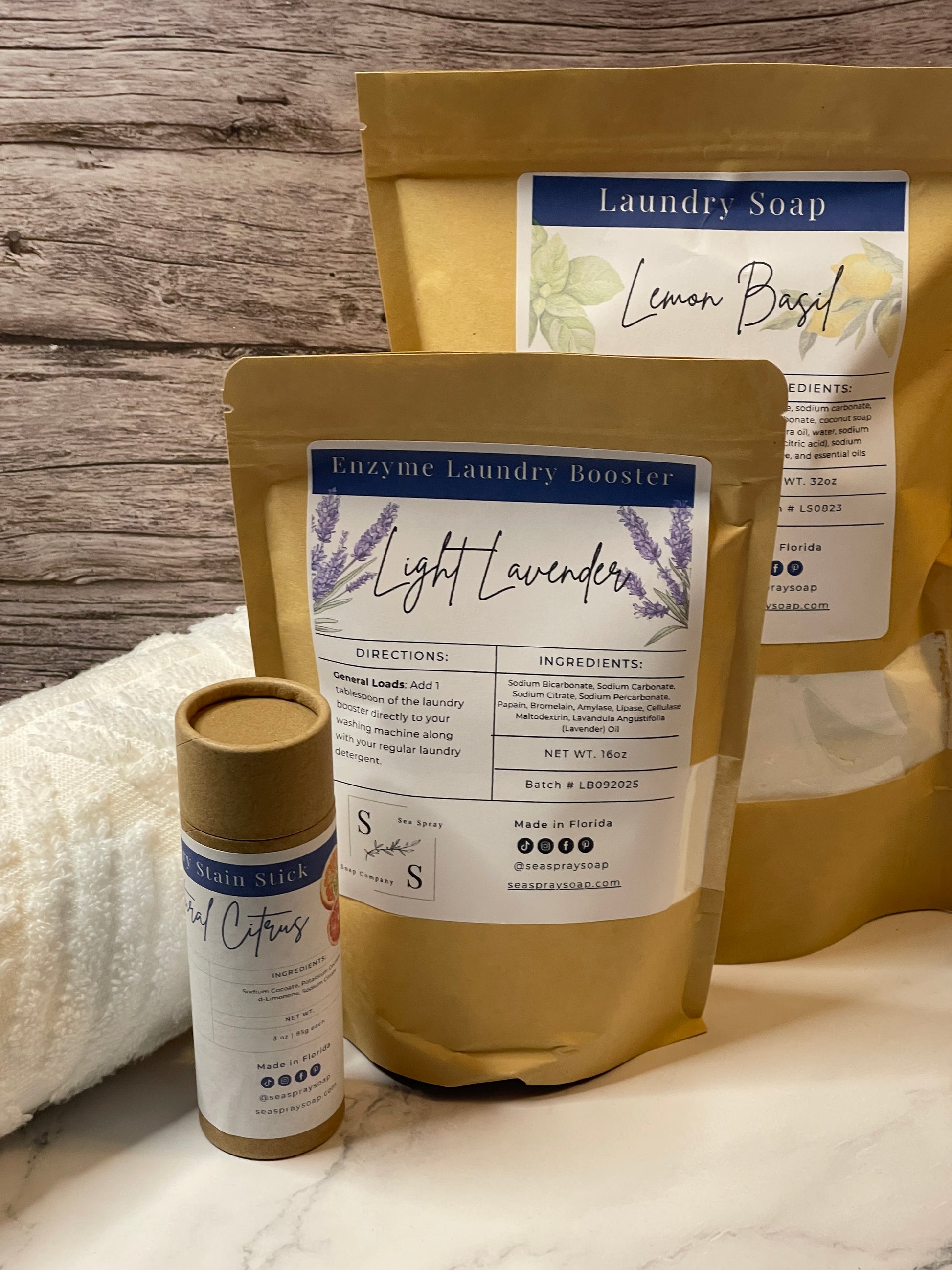 Three bags of laundry soap with labels on a wooden surface