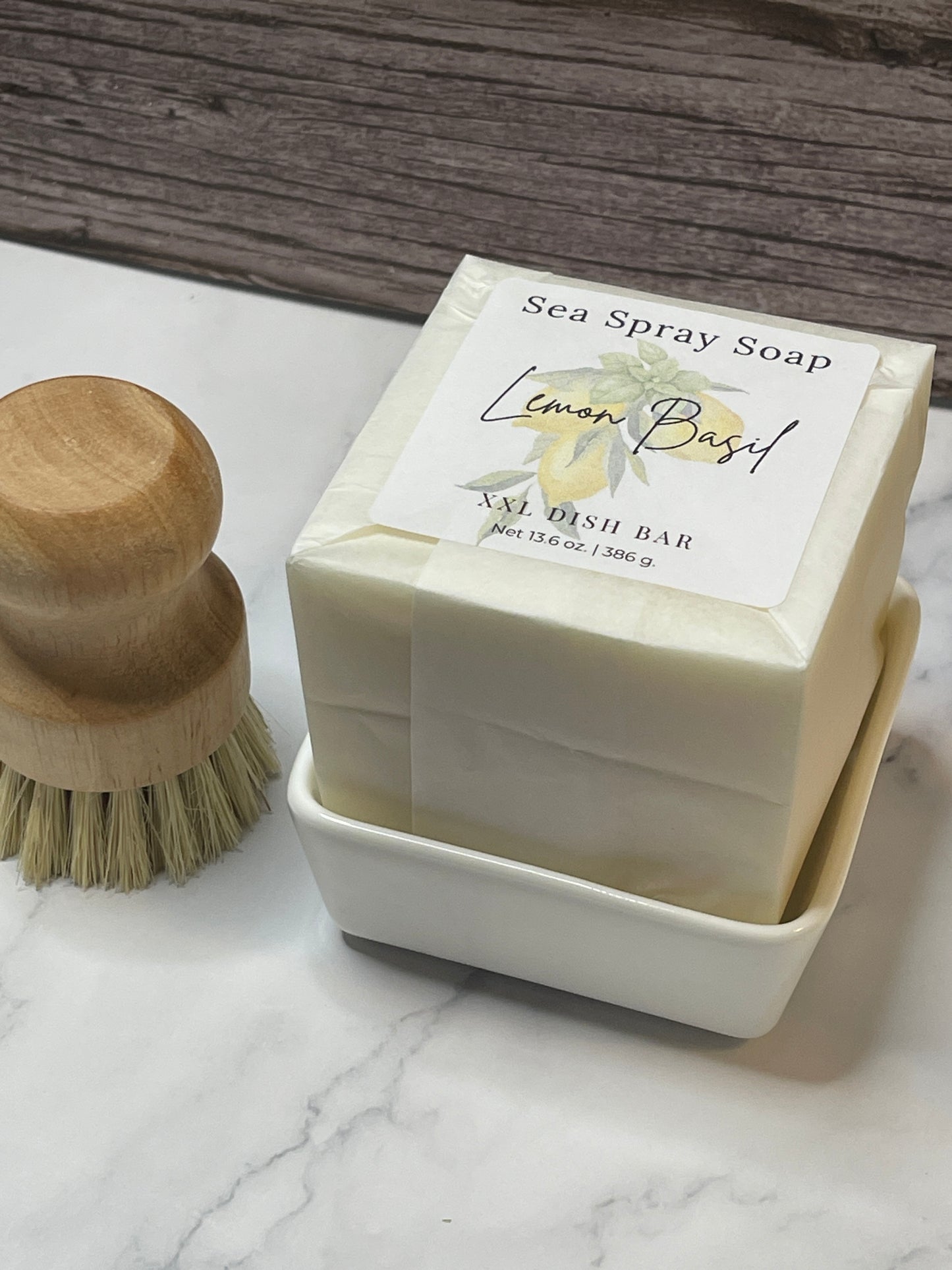Bar of soap with a wooden brush on a marble surface