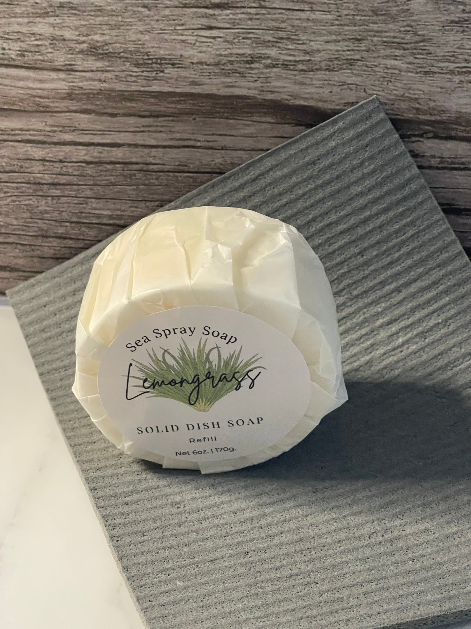 Solid dish soap bar with a label on a textured surface