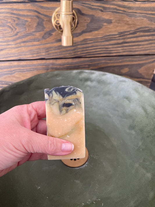 Hand holding a bar of Sea Silk Buttermilk soap bar