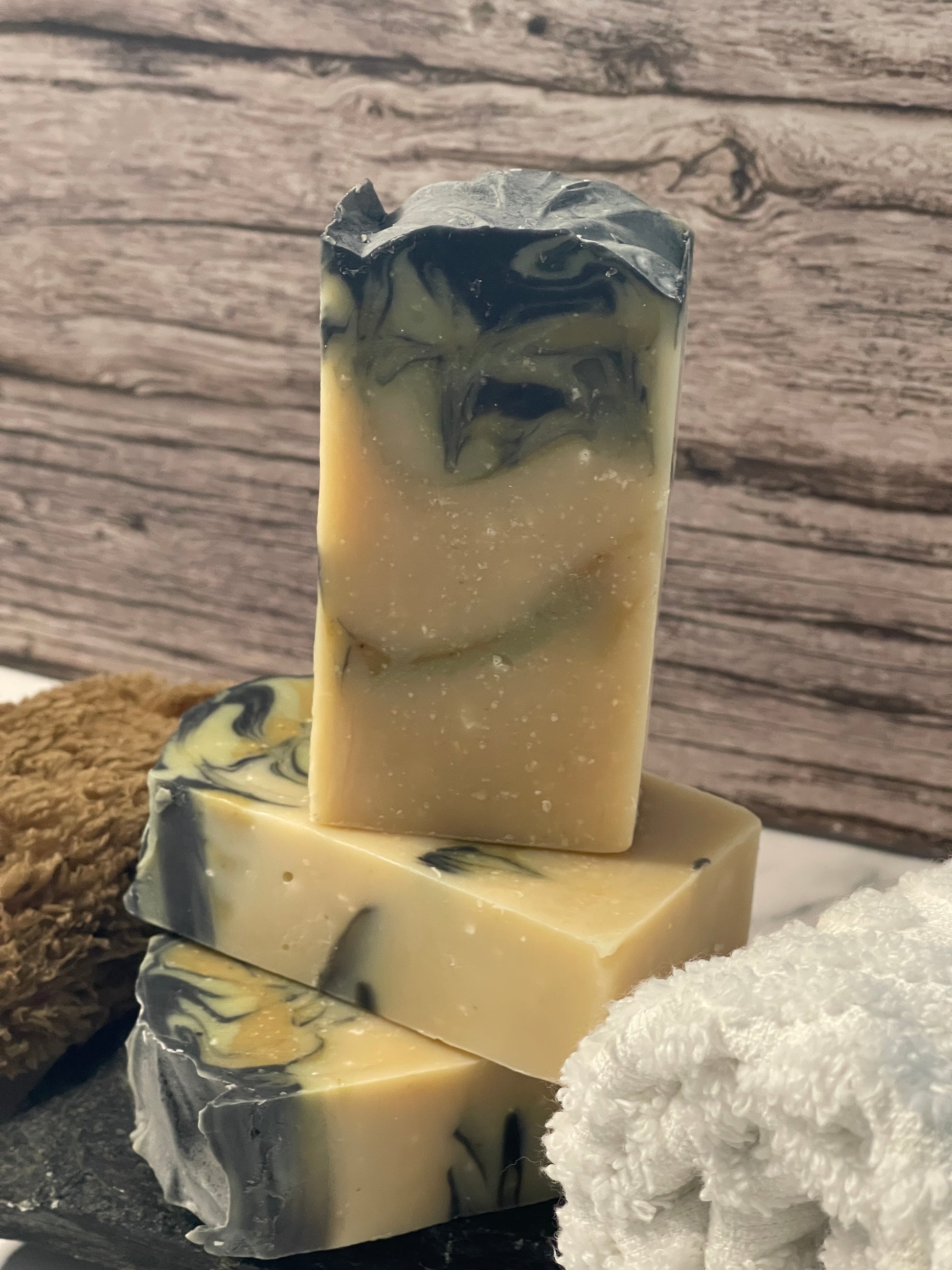 Bar of soap with black and white swirls on a wooden surface