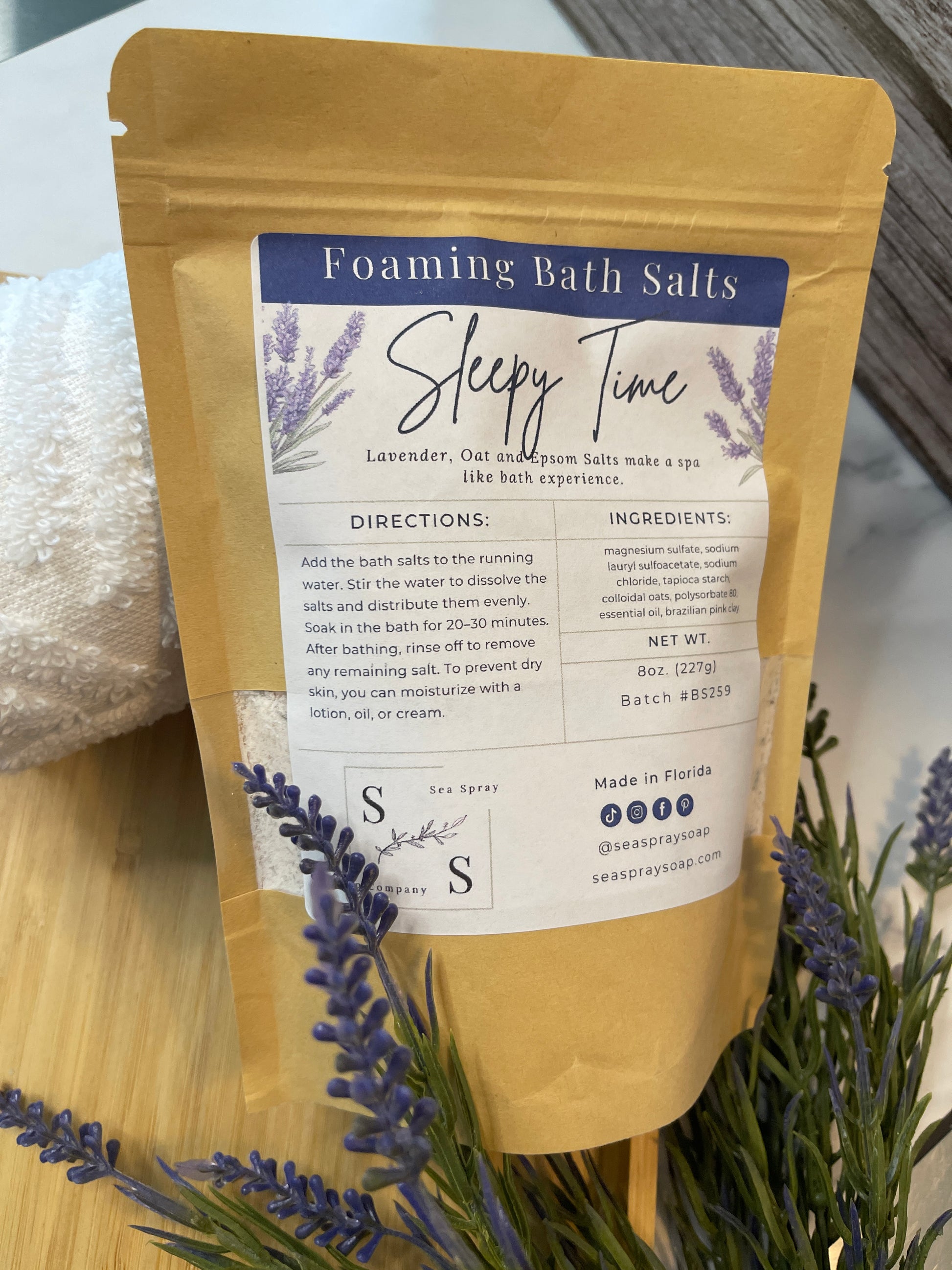 Bag of foaming bath salts with lavender packaging on a wooden surface